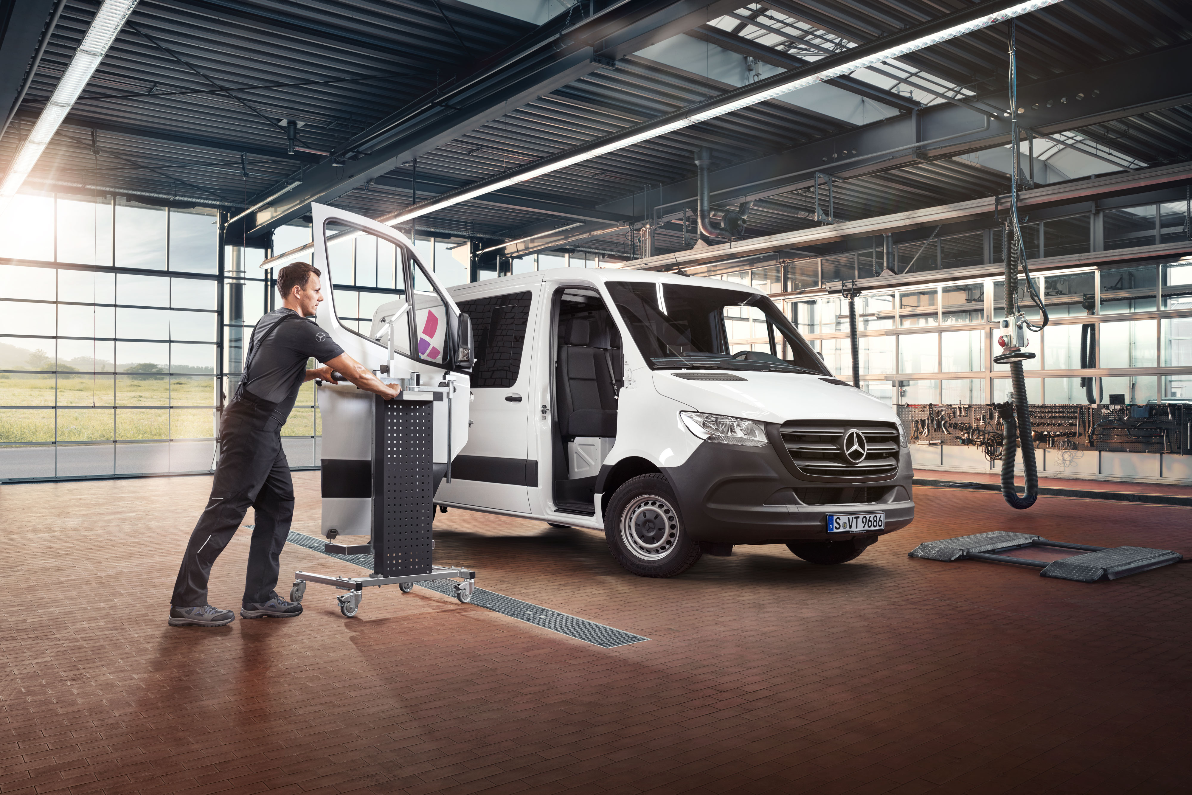 Mercedes-Benz | Ingénierie de la qualité des utilitaires légers Spécialiste Mercedes utilisant Mercedes-Benz Xentry et des outils spéciaux sur un utilitaire léger dans un atelier moderne.