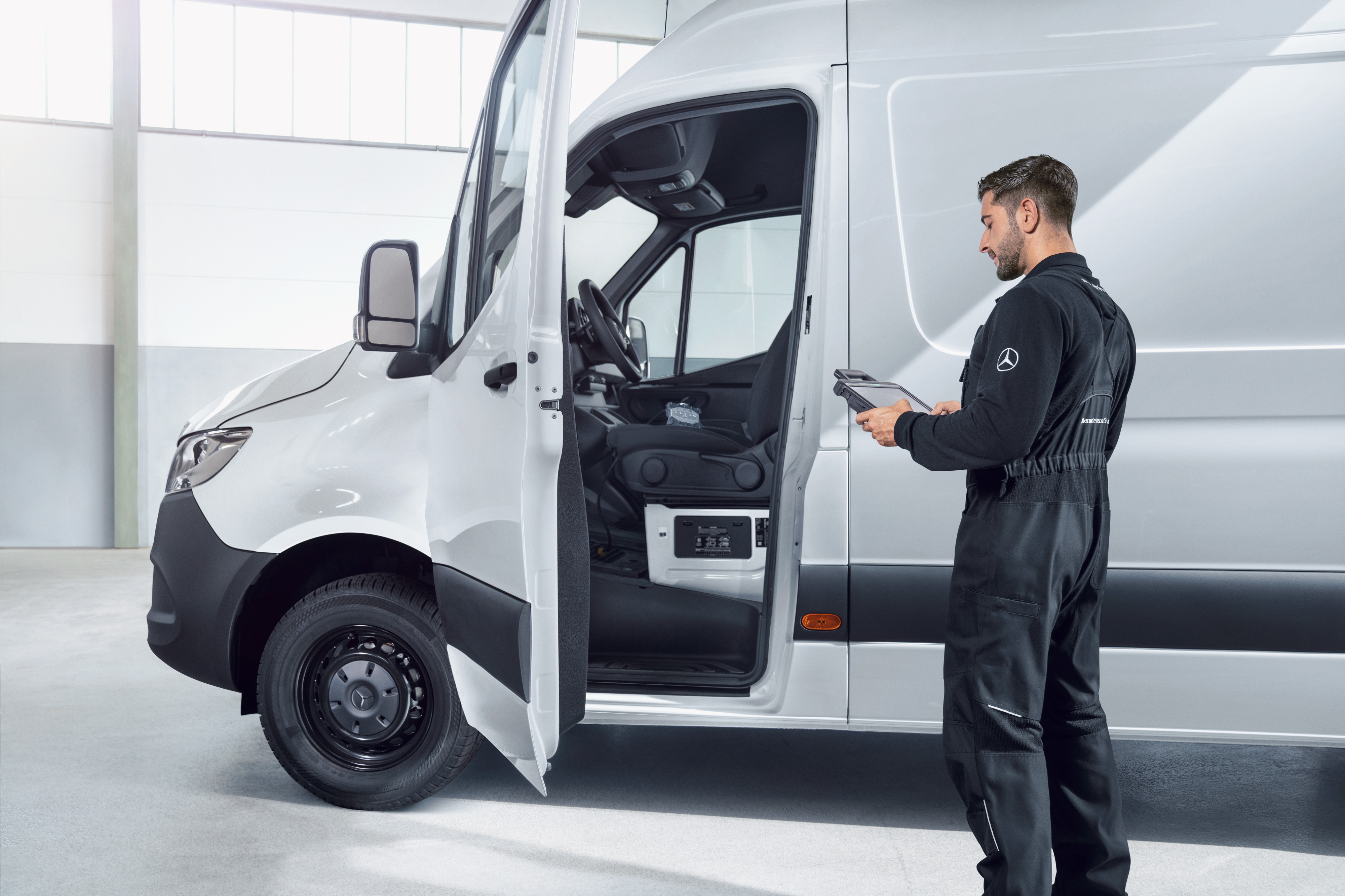 Mercedes-Benz | Serviceübersicht | Fahrzeugwartung Mitarbeiter inspiziert Mercedes-Benz Transporter.