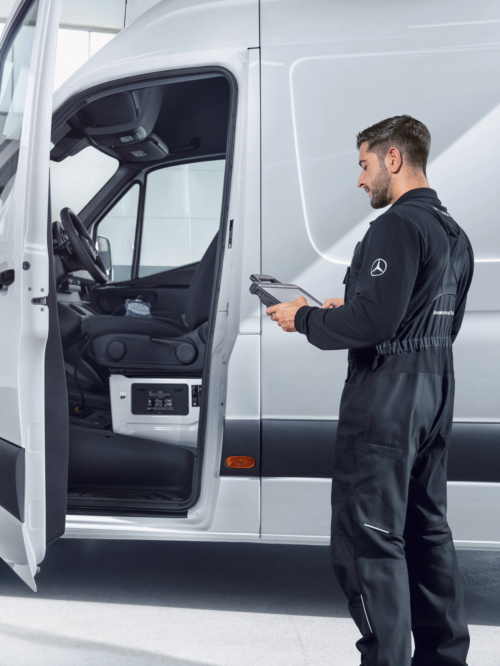 Dipendente ispeziona un veicolo Mercedes-Benz.