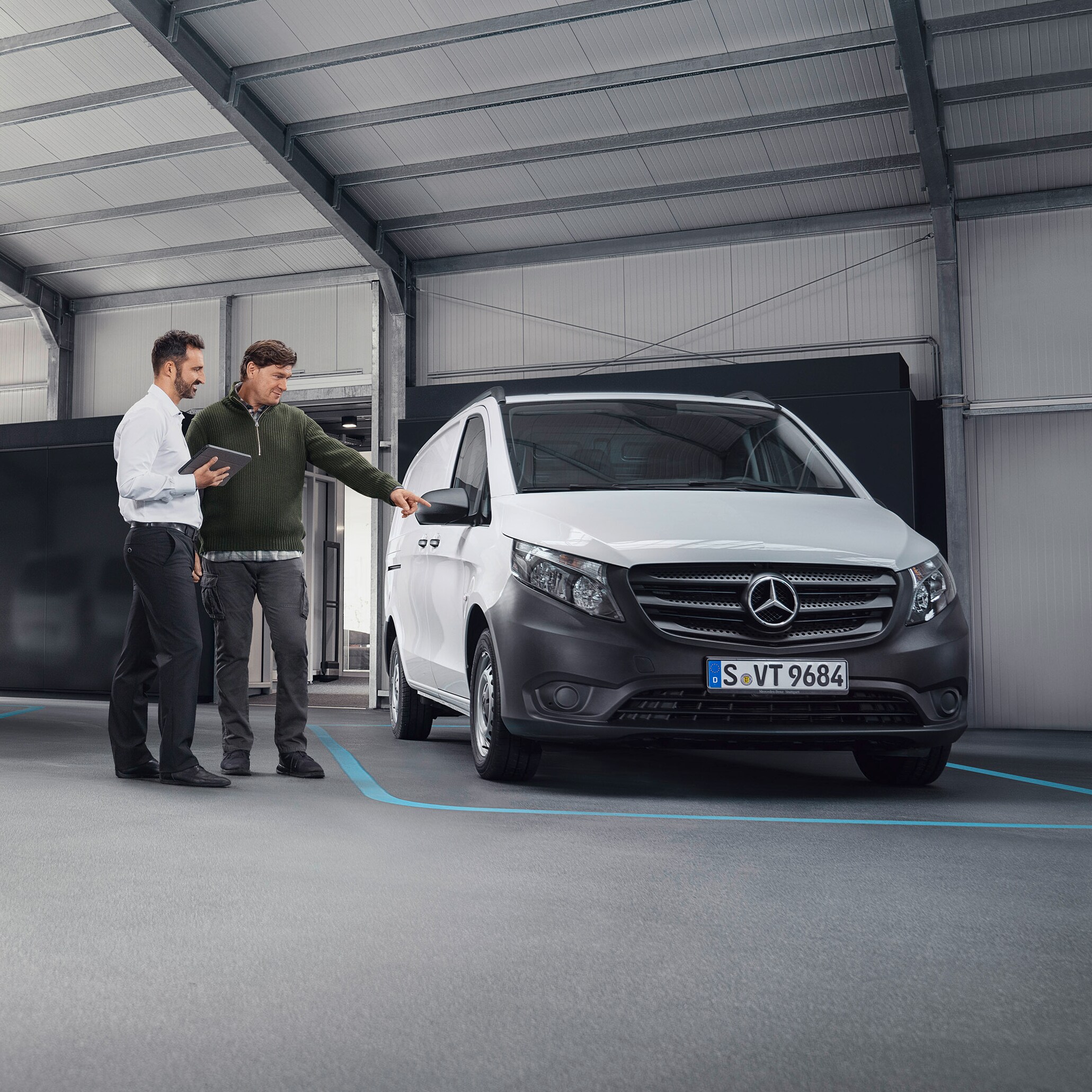 Consulente Mercedes-Benz e cliente davanti a un veicolo.