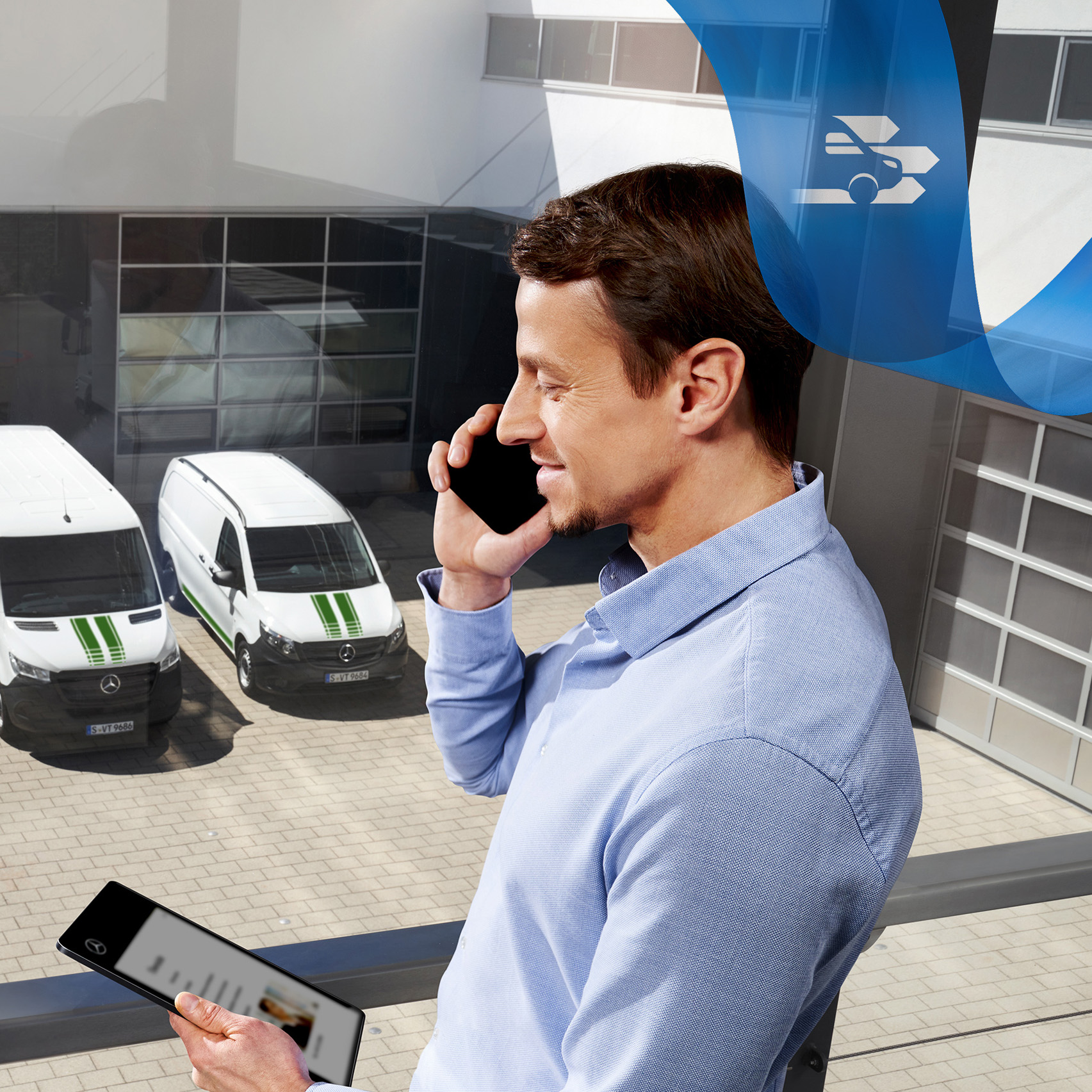 Mercedes-Benz | Transporter Flottendienste Ein Mann telefoniert, während er auf ein Tablet schaut, mit einer Reihe von Mercedes-Benz Transportern im Hintergrund.