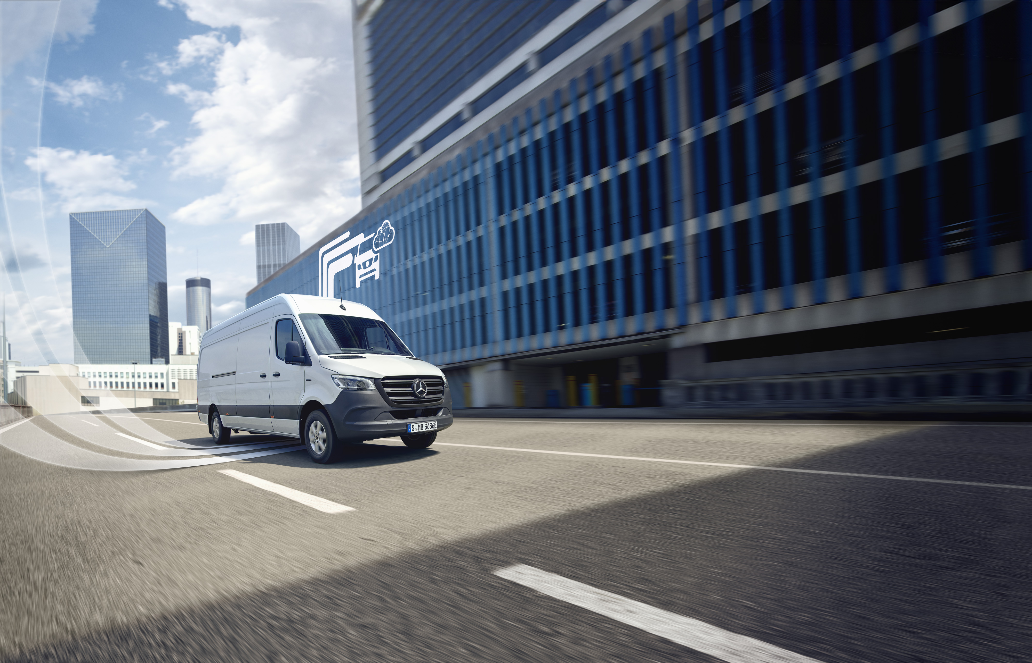 Mercedes-Benz | Technologie des utilitaires légers | Services connectés Utilitaire Mercedes-Benz circulant en ville moderne.
