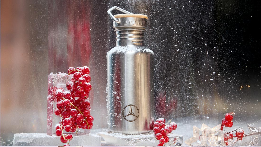 Christmas Stars 2024 di Mercedes-Benz Collection Borraccia in acciaio con logo Mercedes tra ribes ghiacciati.