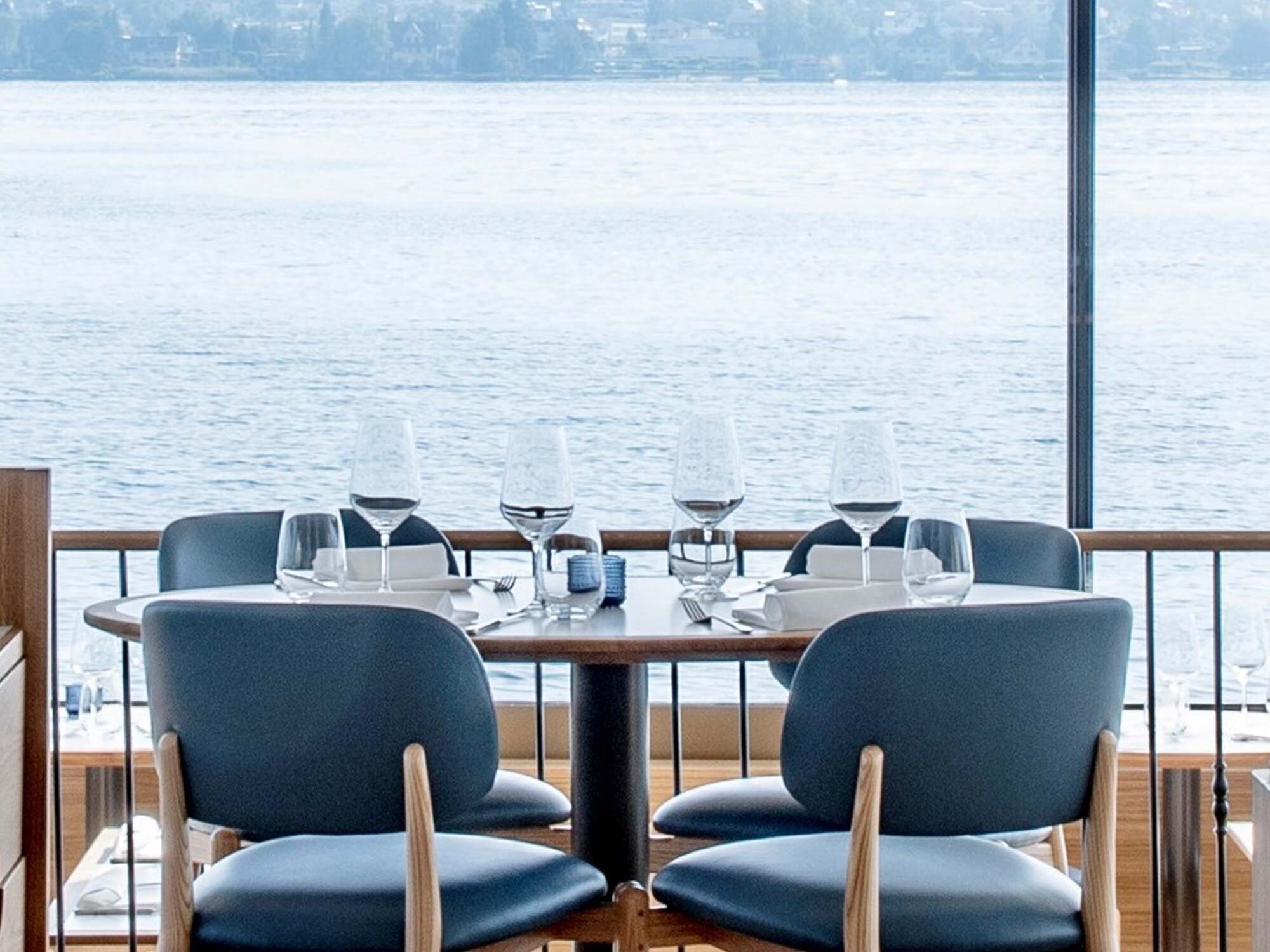 Runder Esstisch im Restaurant Alex Lake mit atemberaubendem Blick auf den Zürichsee.