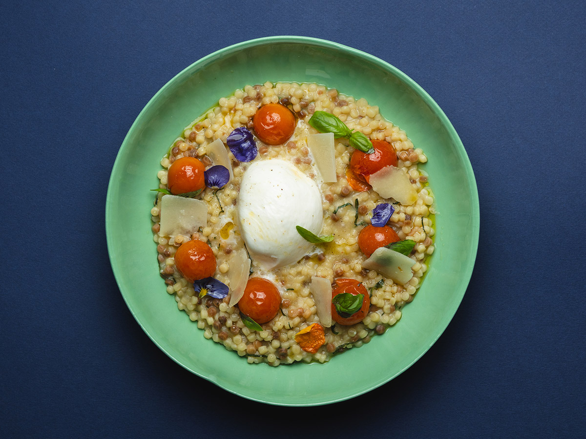 Fregola-Sarda-Risotto Fregola-Sarda-Risotto mit Burrata, Tomaten und Kräutern.