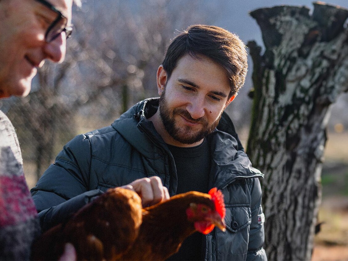 Marco Campanella streichelt ein Huhn beim Bauern.