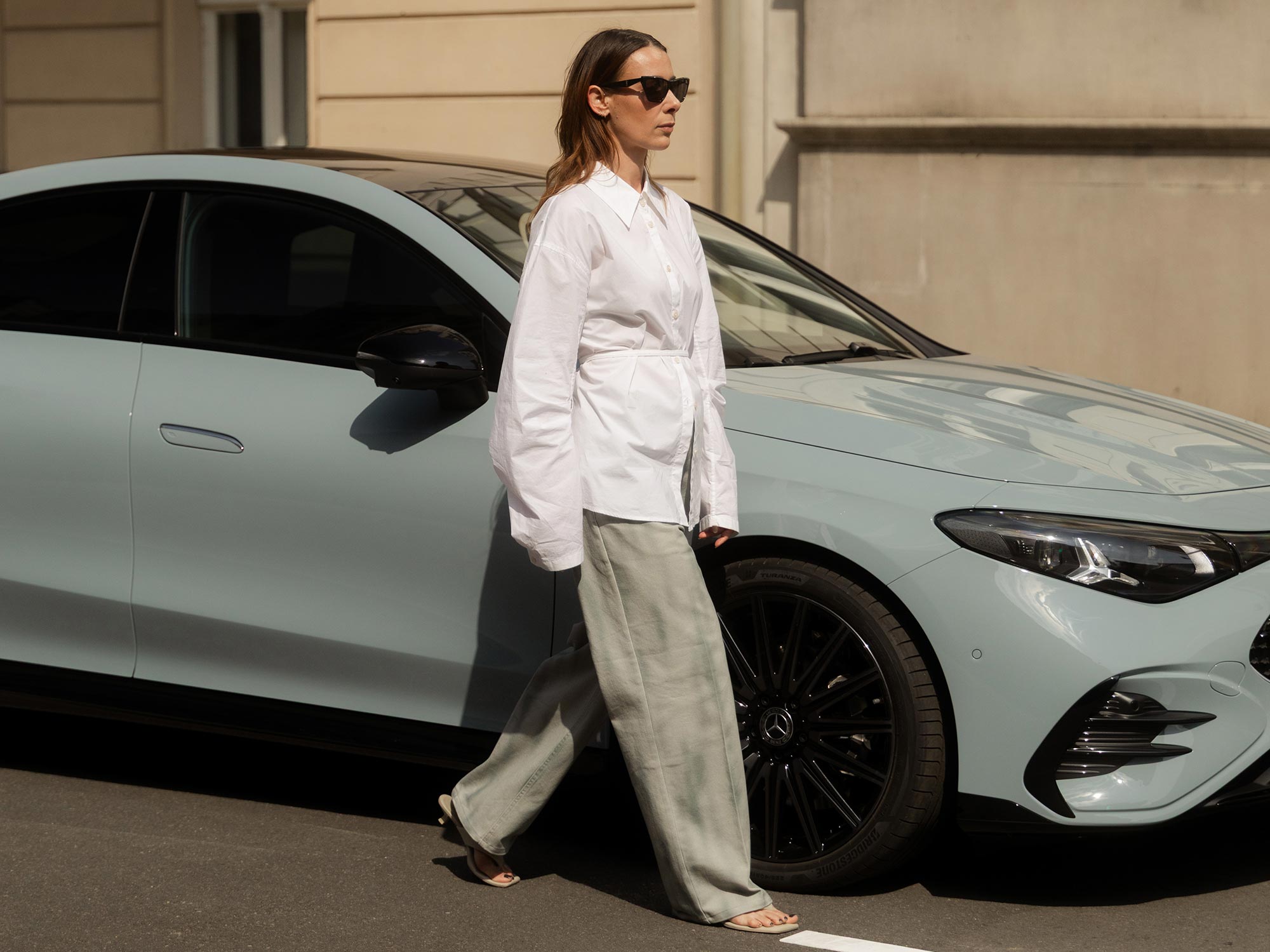 Femme élégante dans un cadre urbain Femme élégante à côté d’une Mercedes-Benz grise.