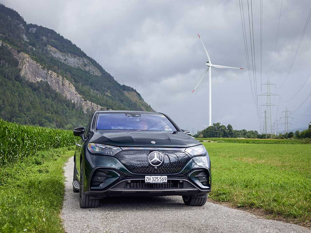 Mercedes-Benz EQE SUV noir devant une éolienne.