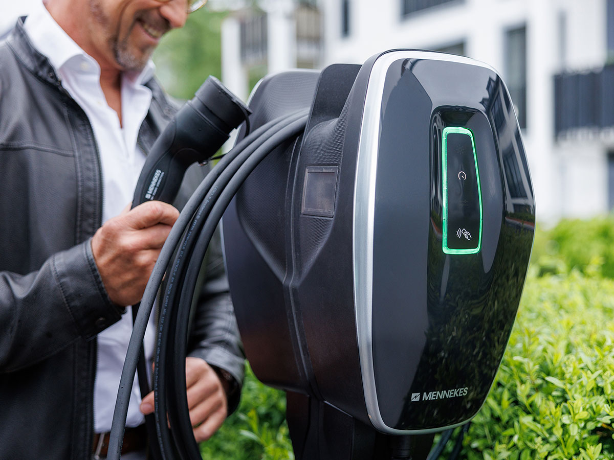 Wallbox Mann hält Kabel einer Wallbox.