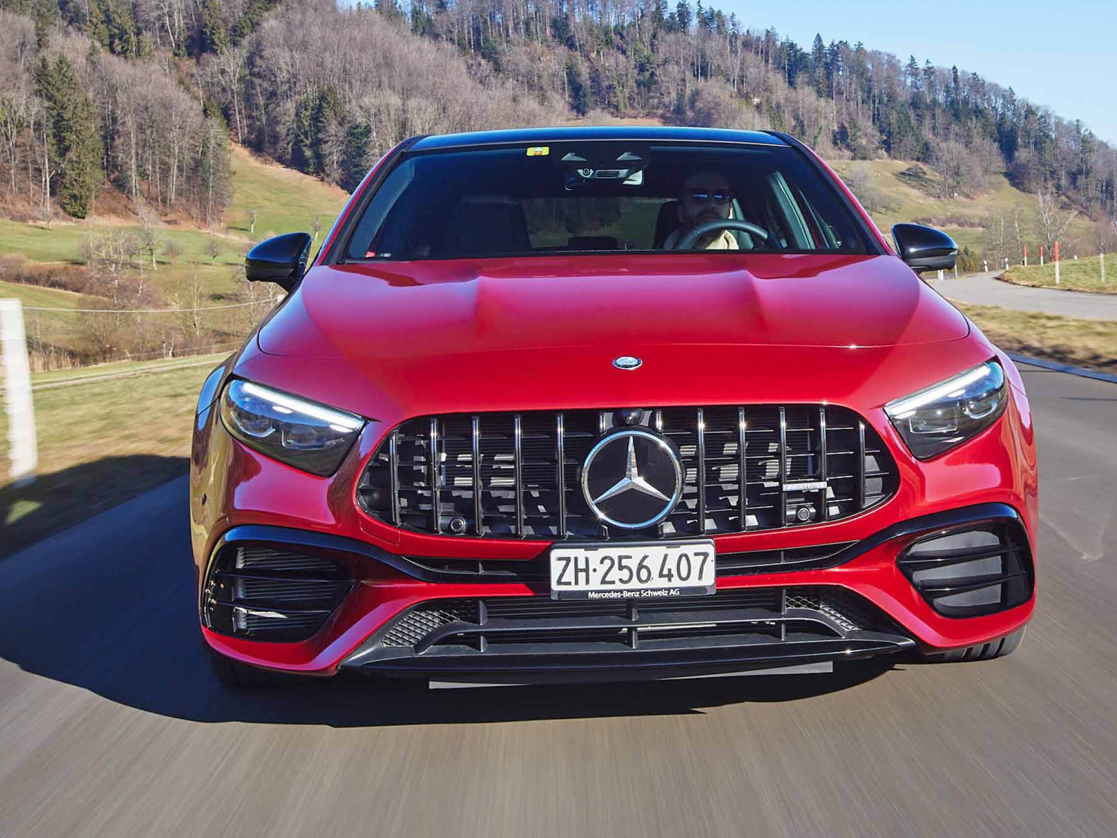 L’AMG A 45 S rossa percorre una strada extraurbana verso l’osservatore.
