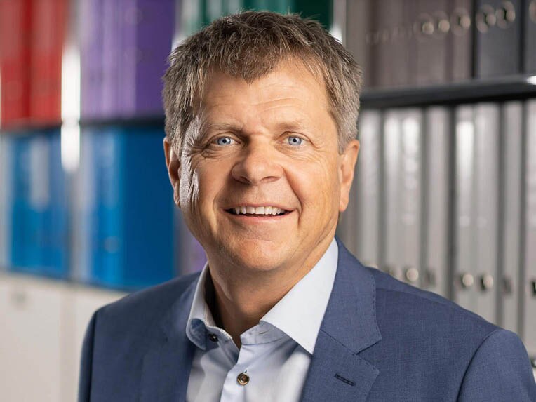 Nationalrat Jürg Grossen vor buntem Aktenregal