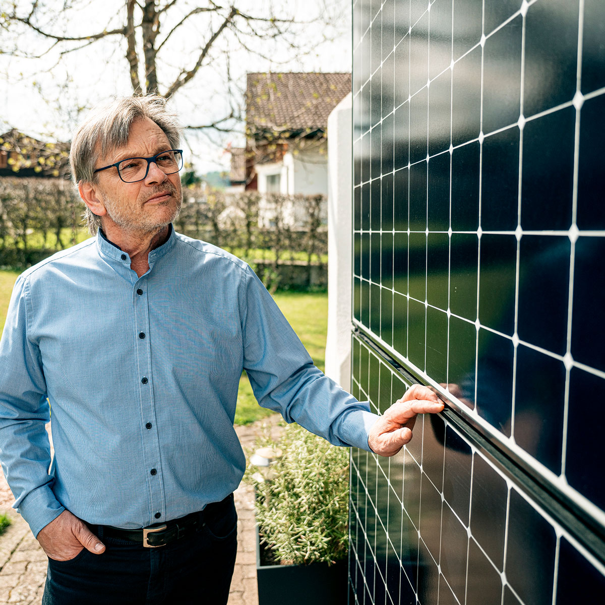 Solarpanels an der Hausfassade Mann betrachtet Solarpanels an der Hausfassade.