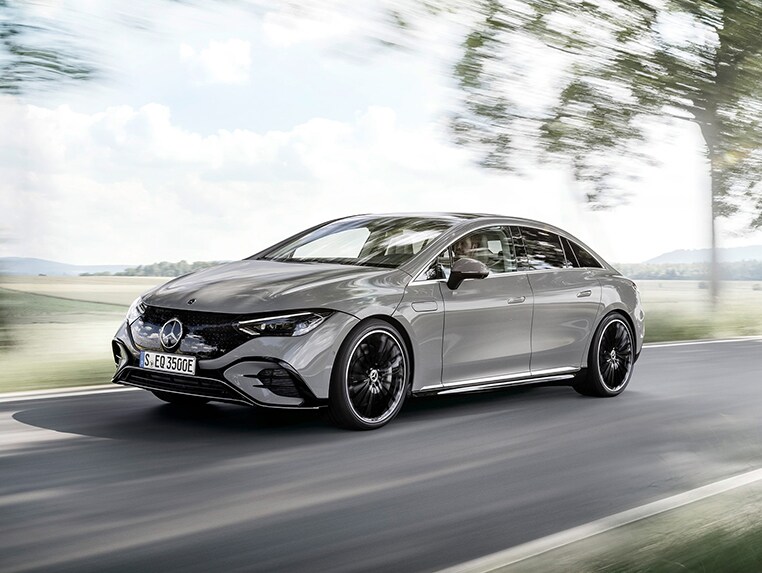 Mercedes EQS auf Strasse, die durchs Grüne führt 