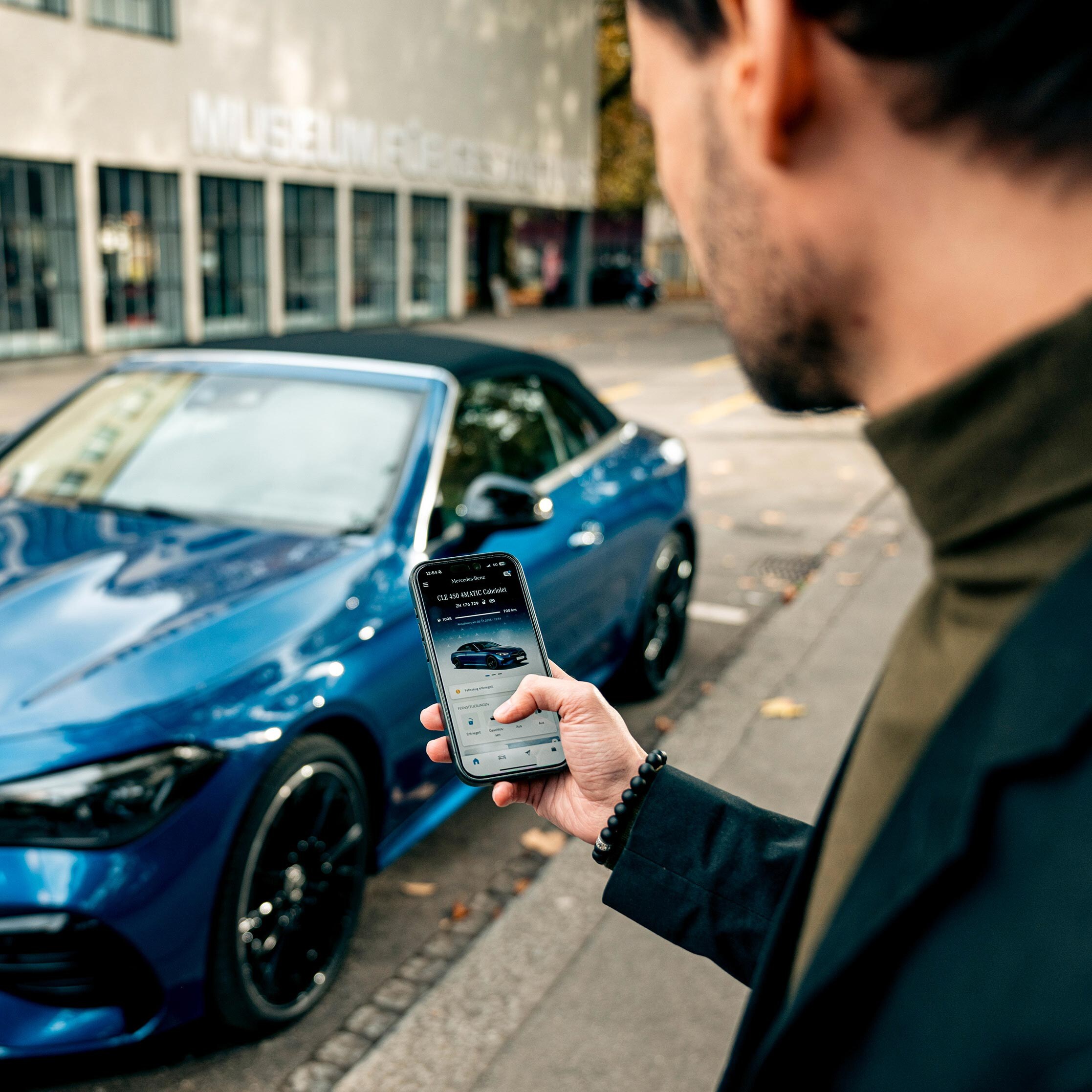 Blaue Mercedes-Benz CLE 450 4MATIC Cabriolet wird per App entriegelt.
