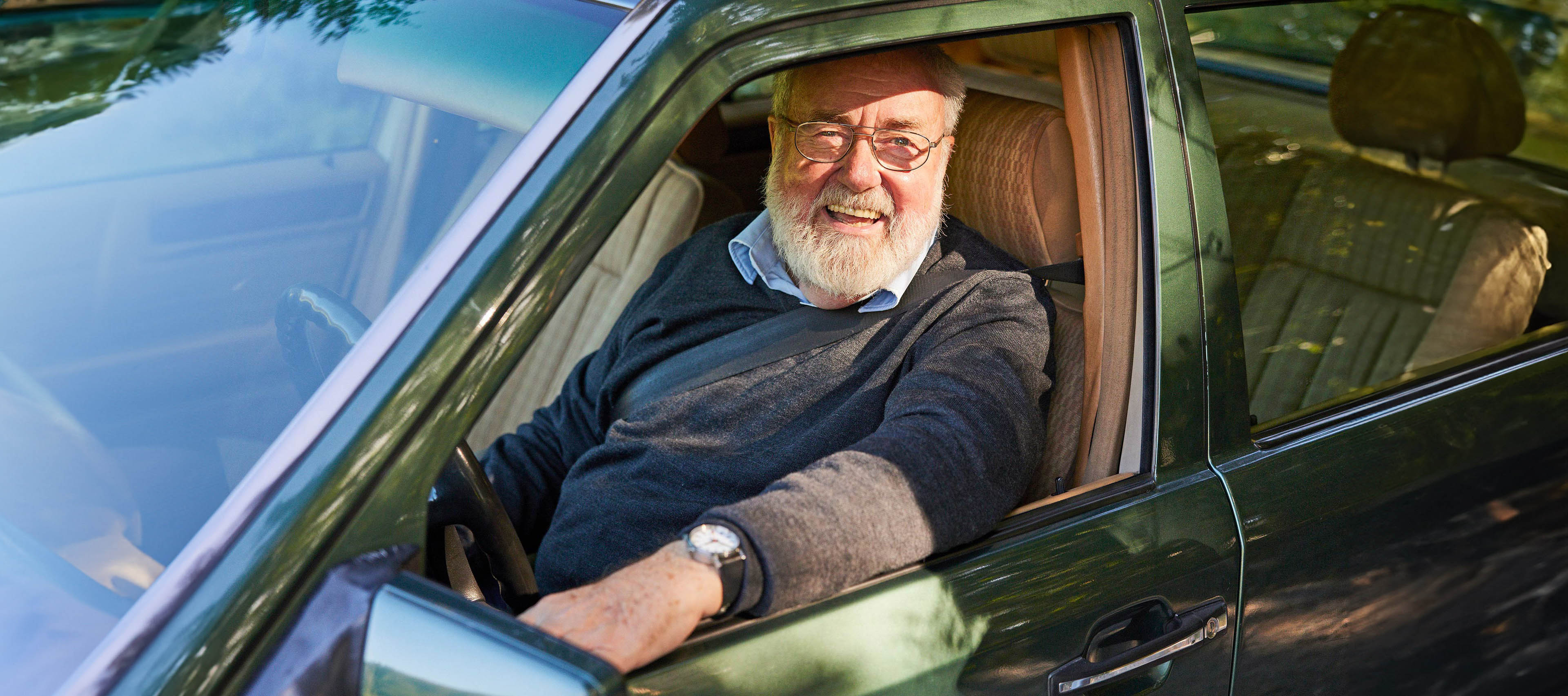 Un homme d’un certain âge est assis dans une vieille voiture verte Un homme d’un certain âge est assis dans une vieille voiture verte