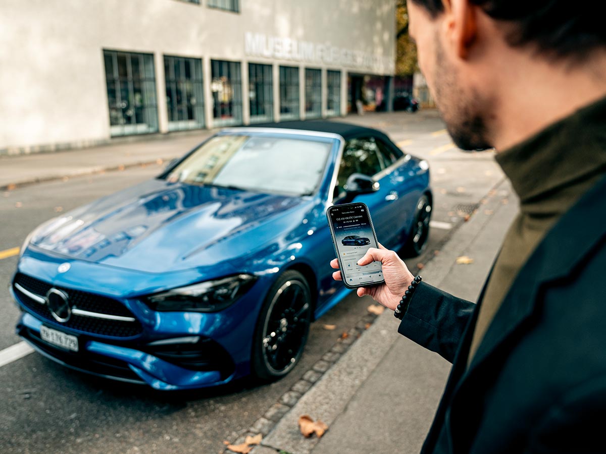 Ein blauer Mercedes-Benz CLE 450 4MATIC Cabriolet wird mittels App entriegelt. Mercedes-Benz CLE 450 4MATIC Cabriolet