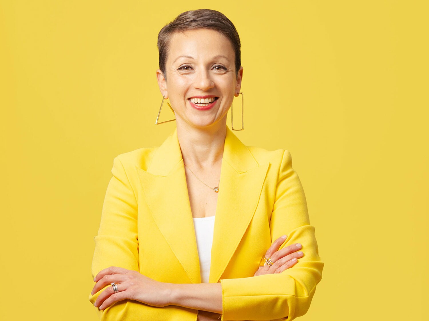 Une femme souriante prénommée Nataly Kogan, vêtue d'un blazer jaune.