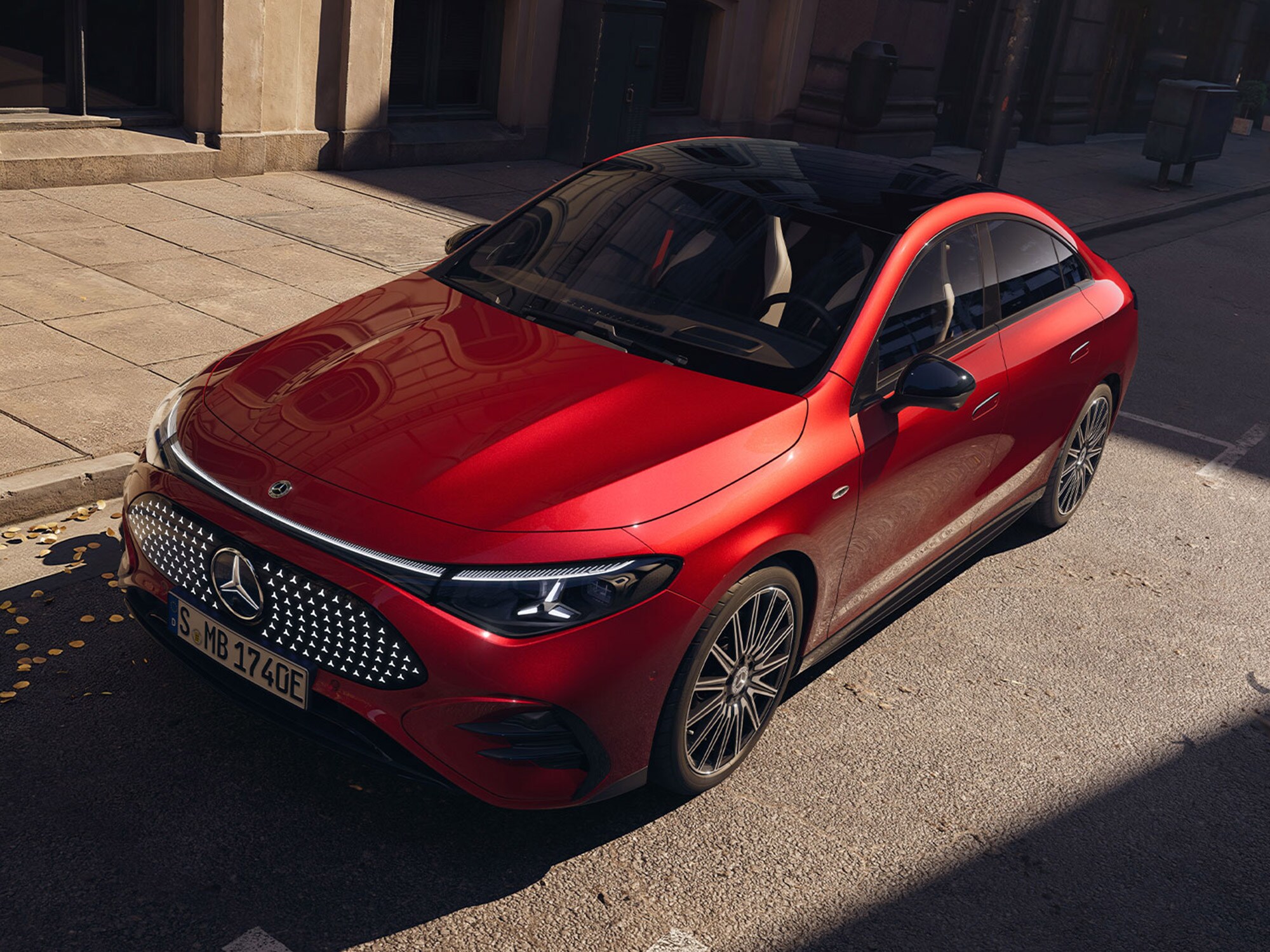 Vista a tre quarti della nuova Mercedes-Benz CLA rossa in un contesto urbano. 