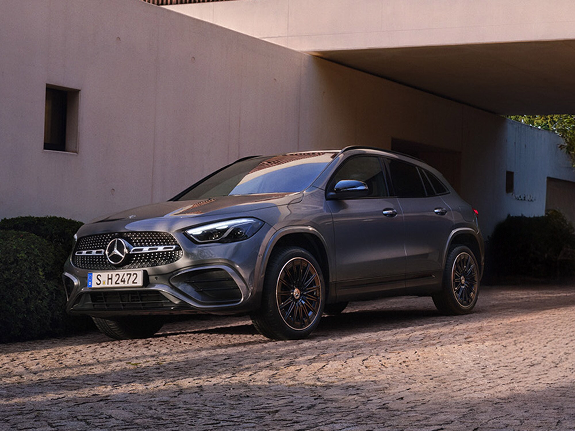 Mercedes-Benz GLA seitlich geparkt auf einer Auffahrt, vor einem modernen Gebäude.