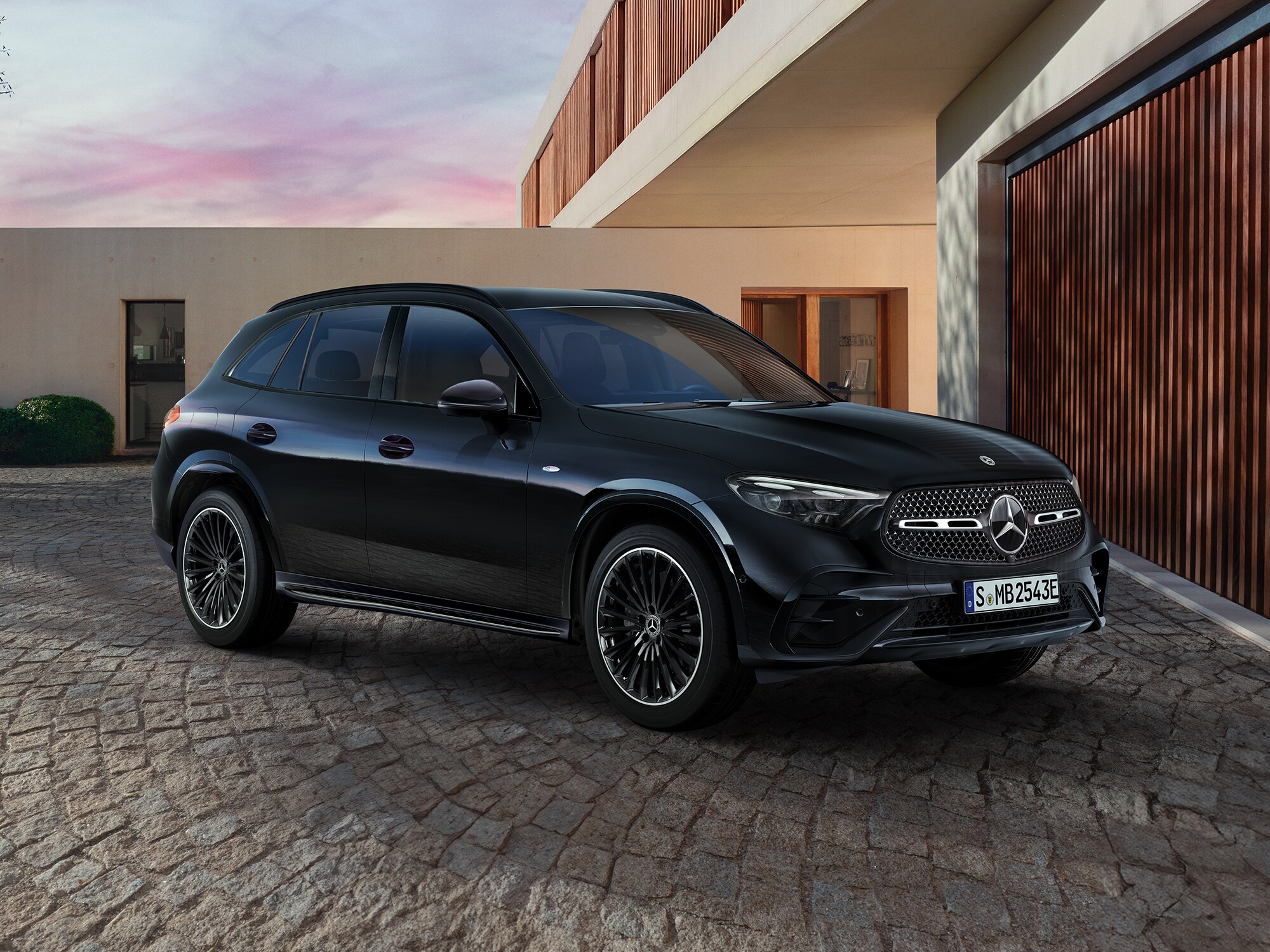Mercedes-Benz GLC seitlich geparkt auf einer Auffahrt, vor einem modernen Gebäude.