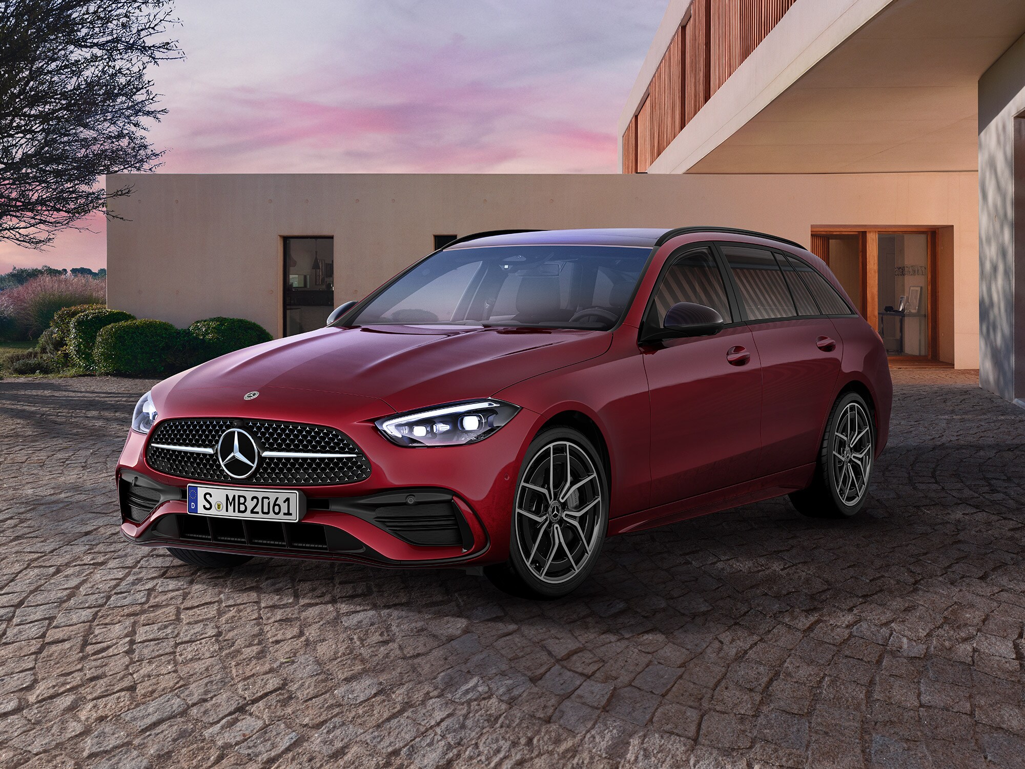 Mercedes-Benz C-Klasse T-Modell seitlich geparkt vor einer modernen Garage mit Einfahrt.