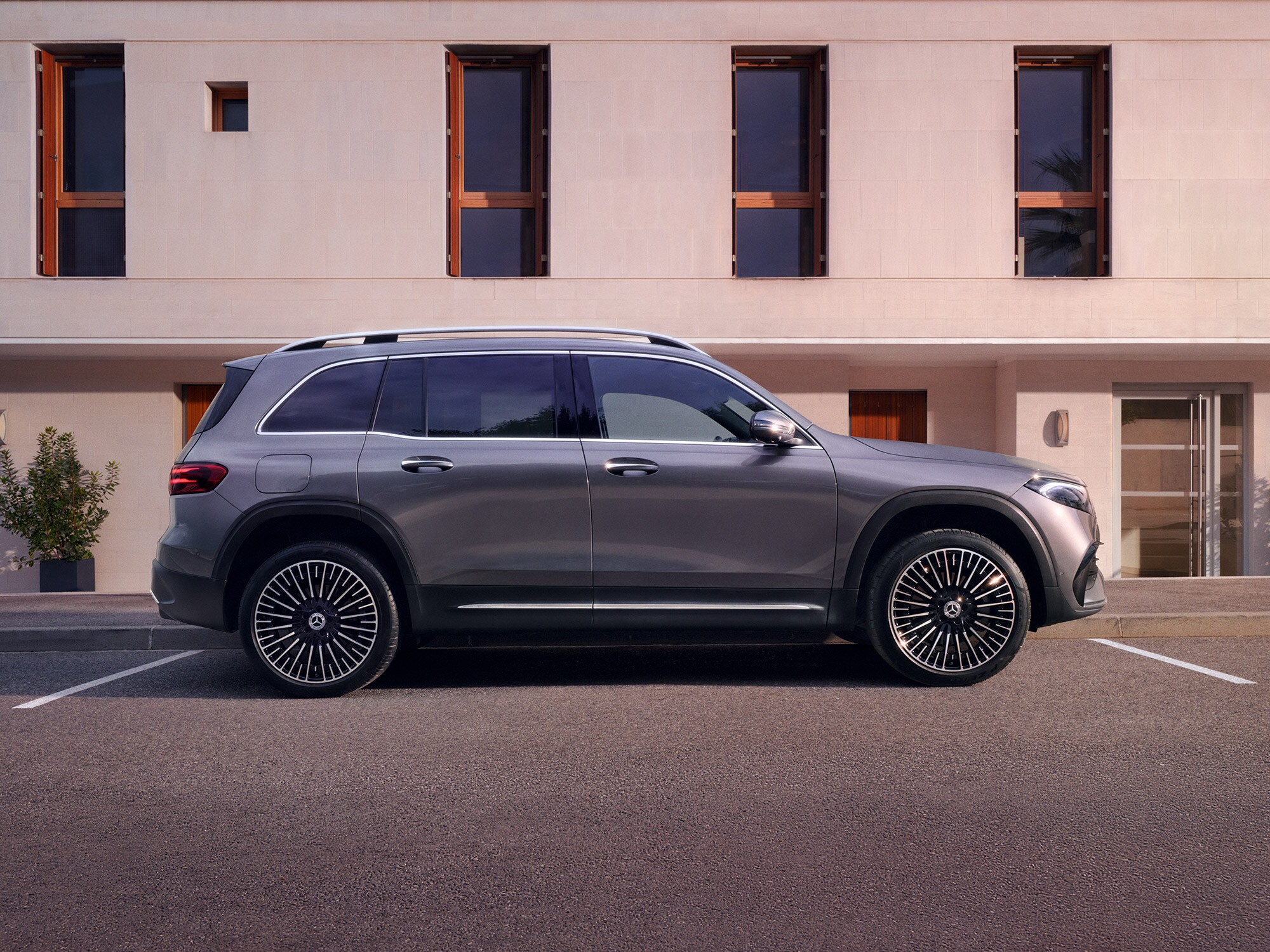 Mercedes-Benz EQB parcheggiata lateralmente davanti a una casa moderna.
