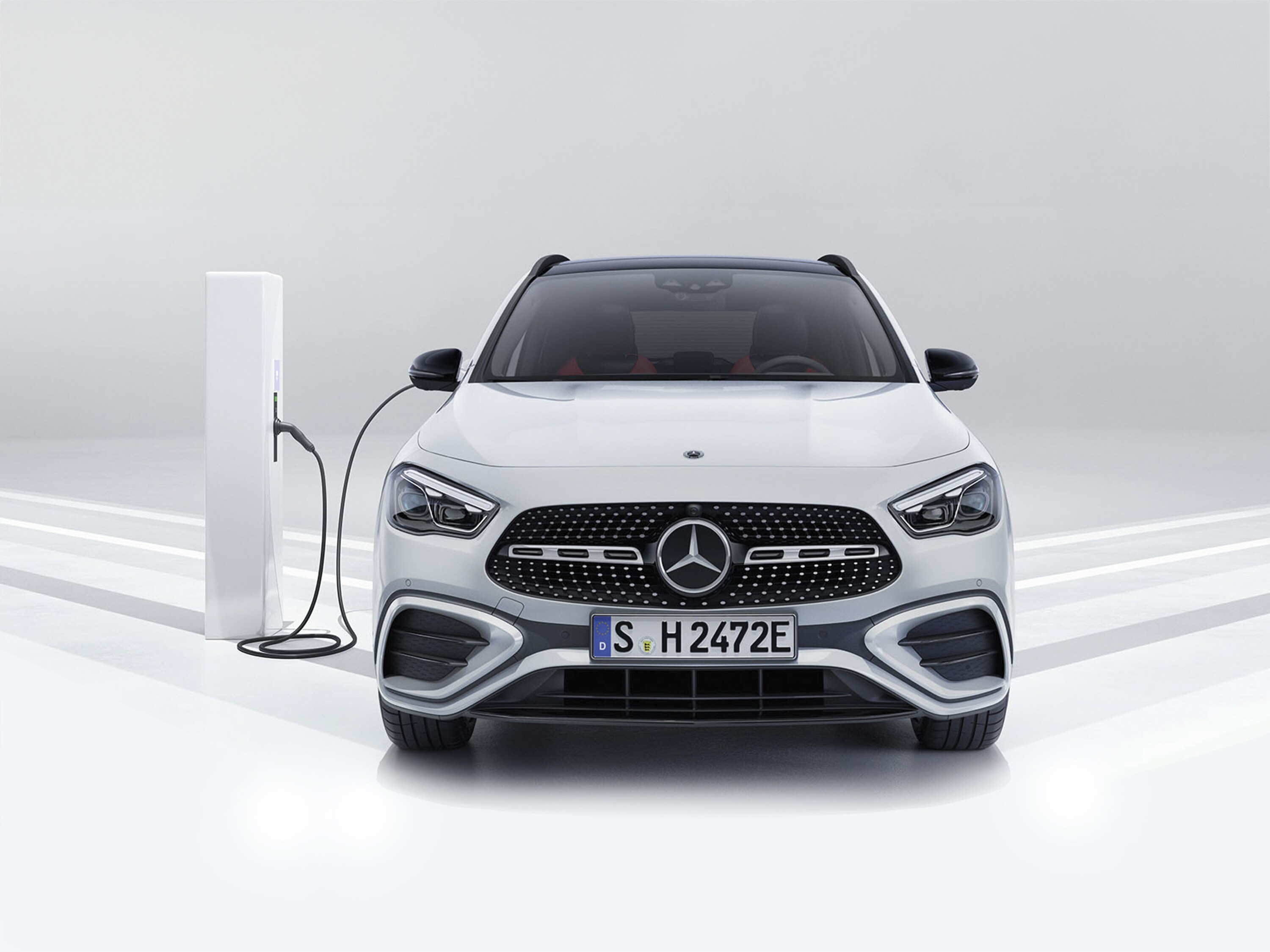 Weisser Mercedes an einer Ladestation, Frontansicht.