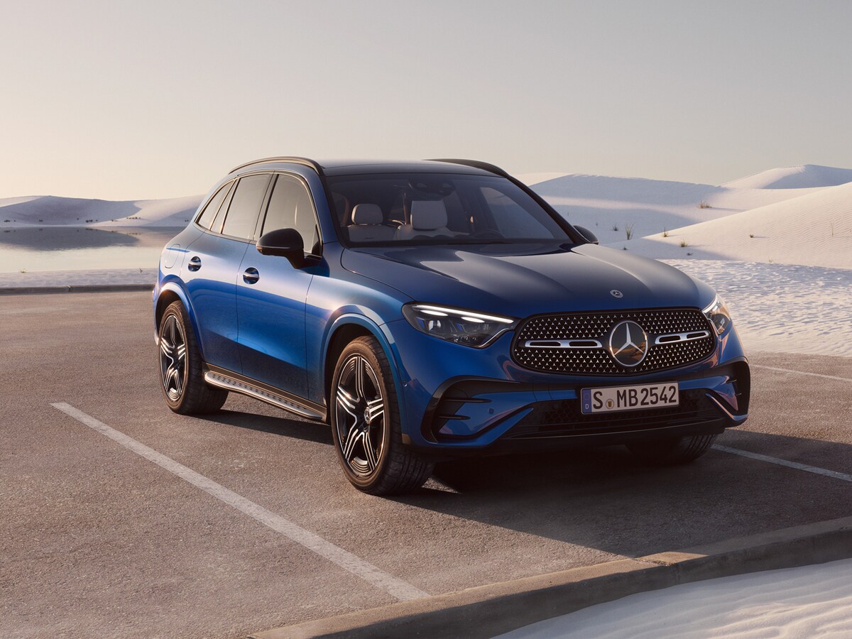 SUV Mercedes blu su una strada in un paesaggio invernale.