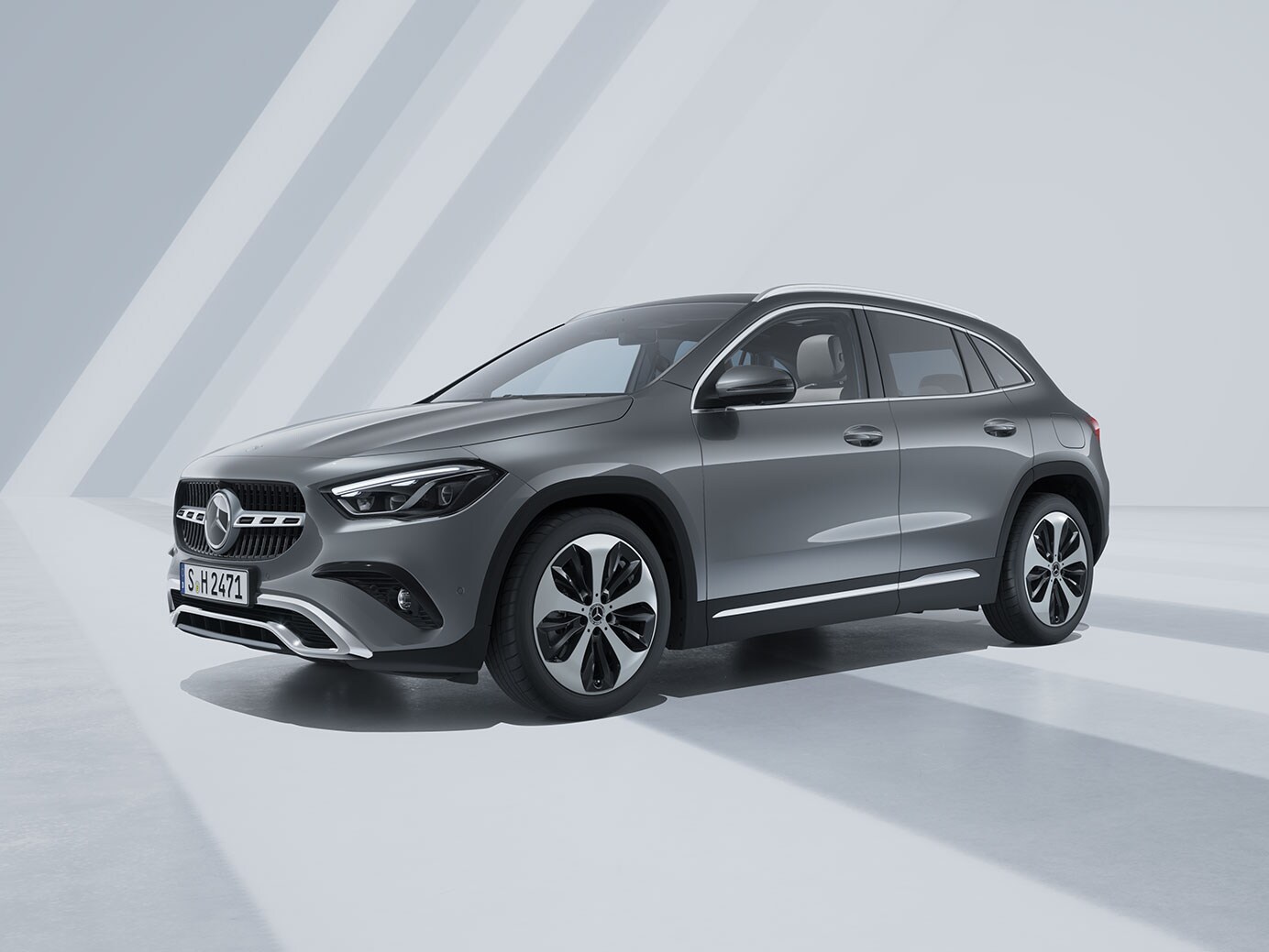 SUV Mercedes grigio in un ambiente chiaro e geometrico.
