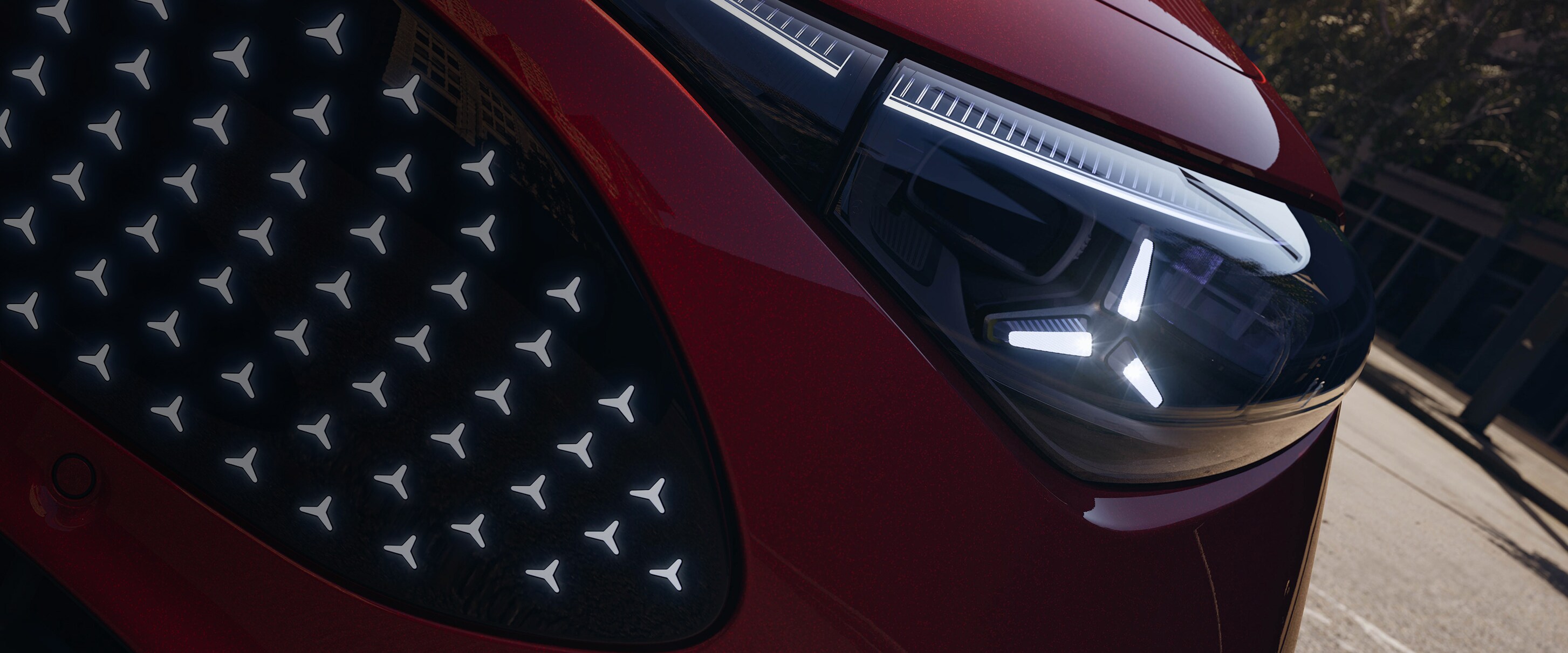 Detailaufnahme der Fahrzeugfront mit markantem LED-Scheinwerfer und beleuchtetem Kühlergrill.