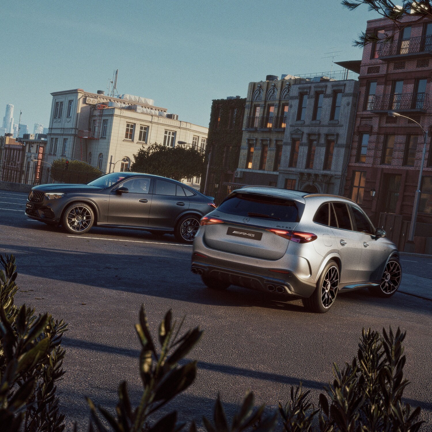 Le Mercedes-AMG GLC 53 SUV e Coupé in un parcheggio, sullo sfondo un moderno paesaggio urbano.