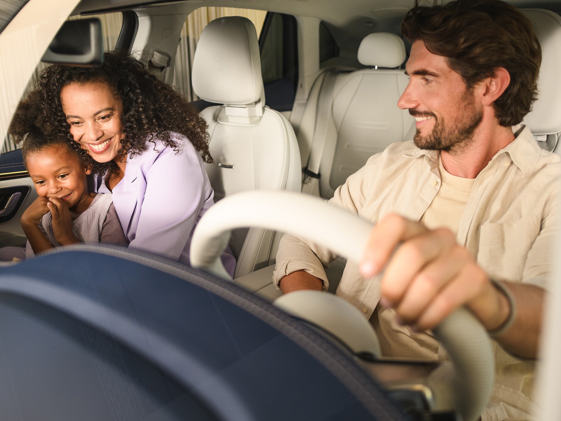 Zwei Personen und ein Kind in einem Mercedes-Benz Fahrzeug.