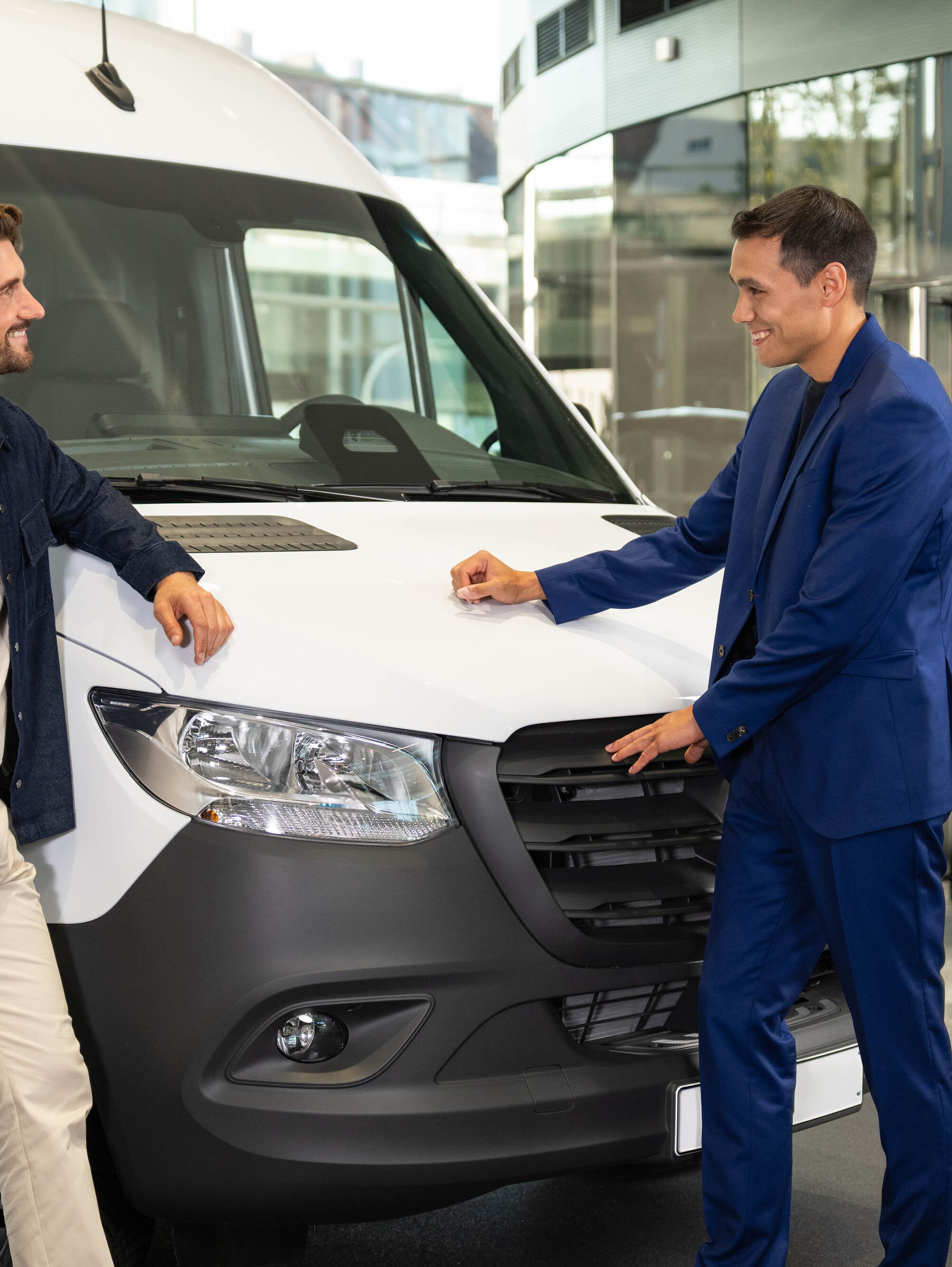 Due persone sono appoggiate a un van Mercedes-Benz  e conversano.