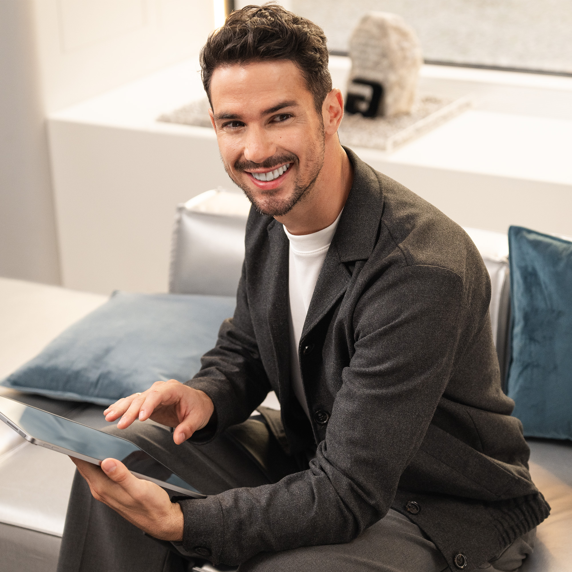 Homme souriant avec ordinateur portable Homme sur un canapé avec ordinateur portable souriant