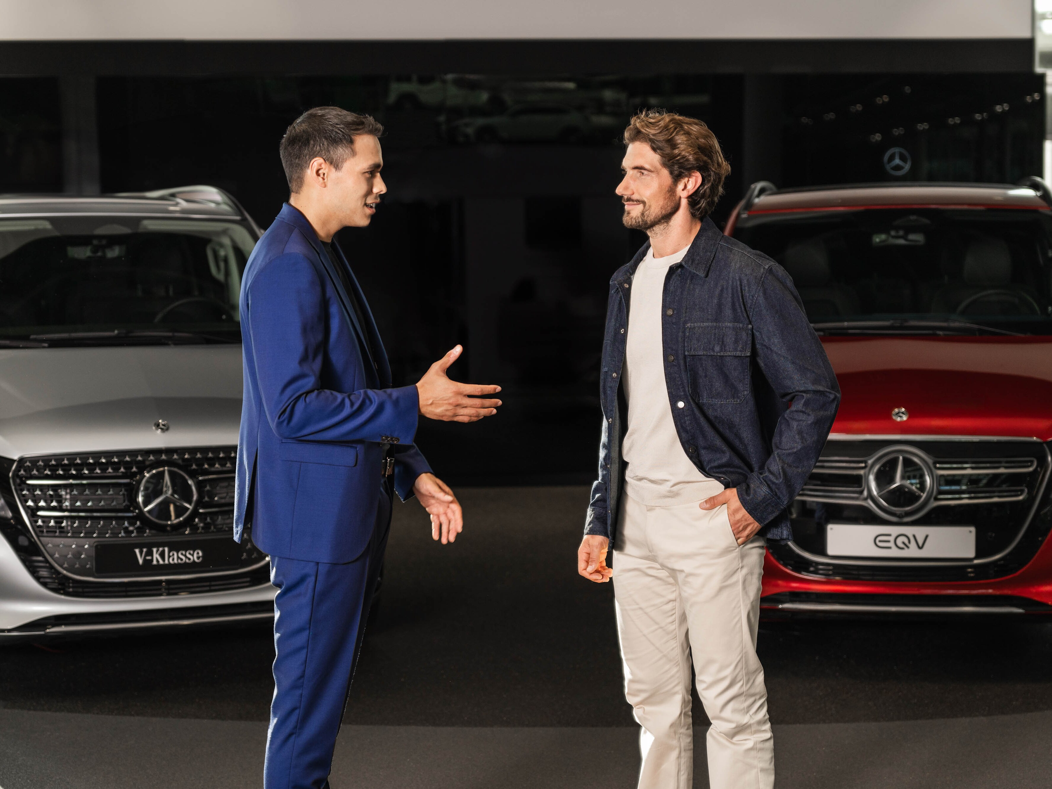 Deux personnes discutent devant deux vans Mercedes-Benz.