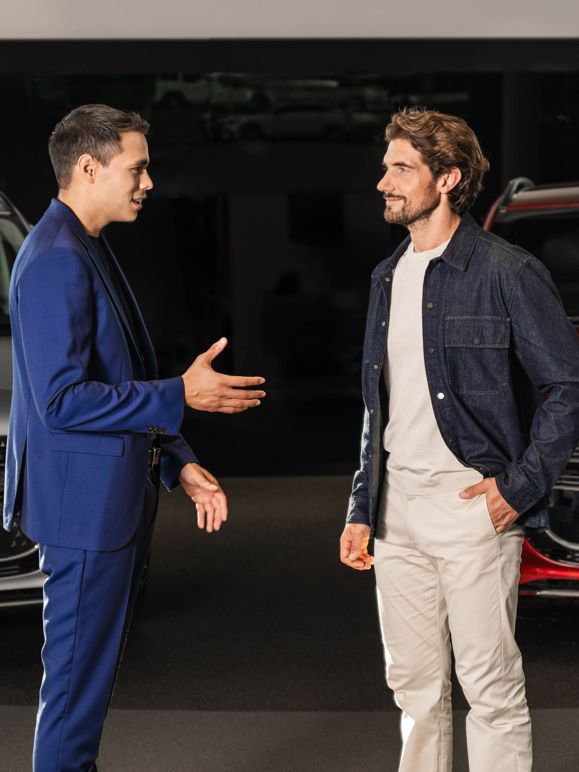 Due persone conversano davanti a due van Mercedes-Benz.