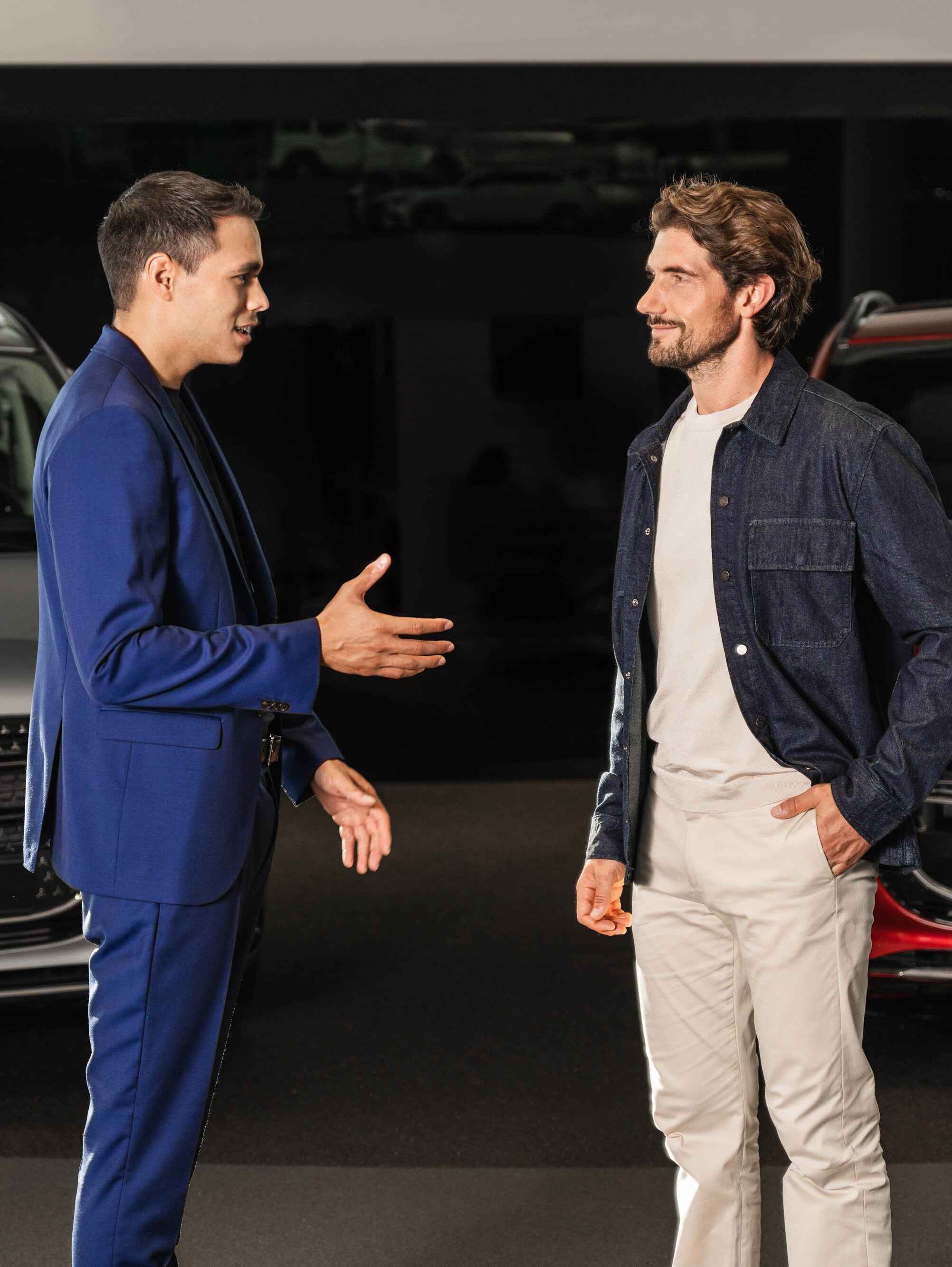 Zwei Personen unterhalten sich vor zwei Mercedes-Benz Vans.