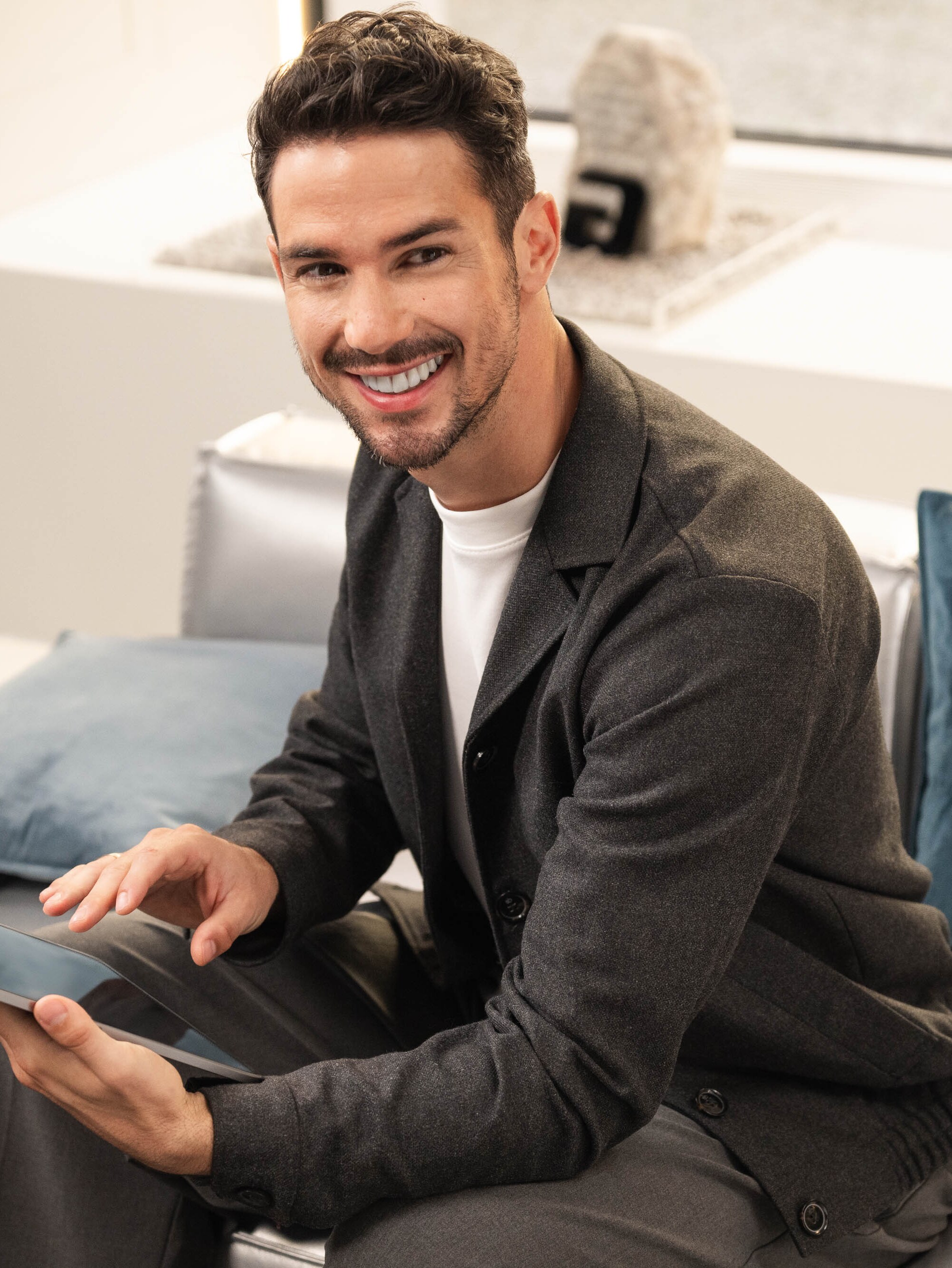 Eine Person, die auf einem Sofa sitzt und ihr Mobilgerät nutzt.