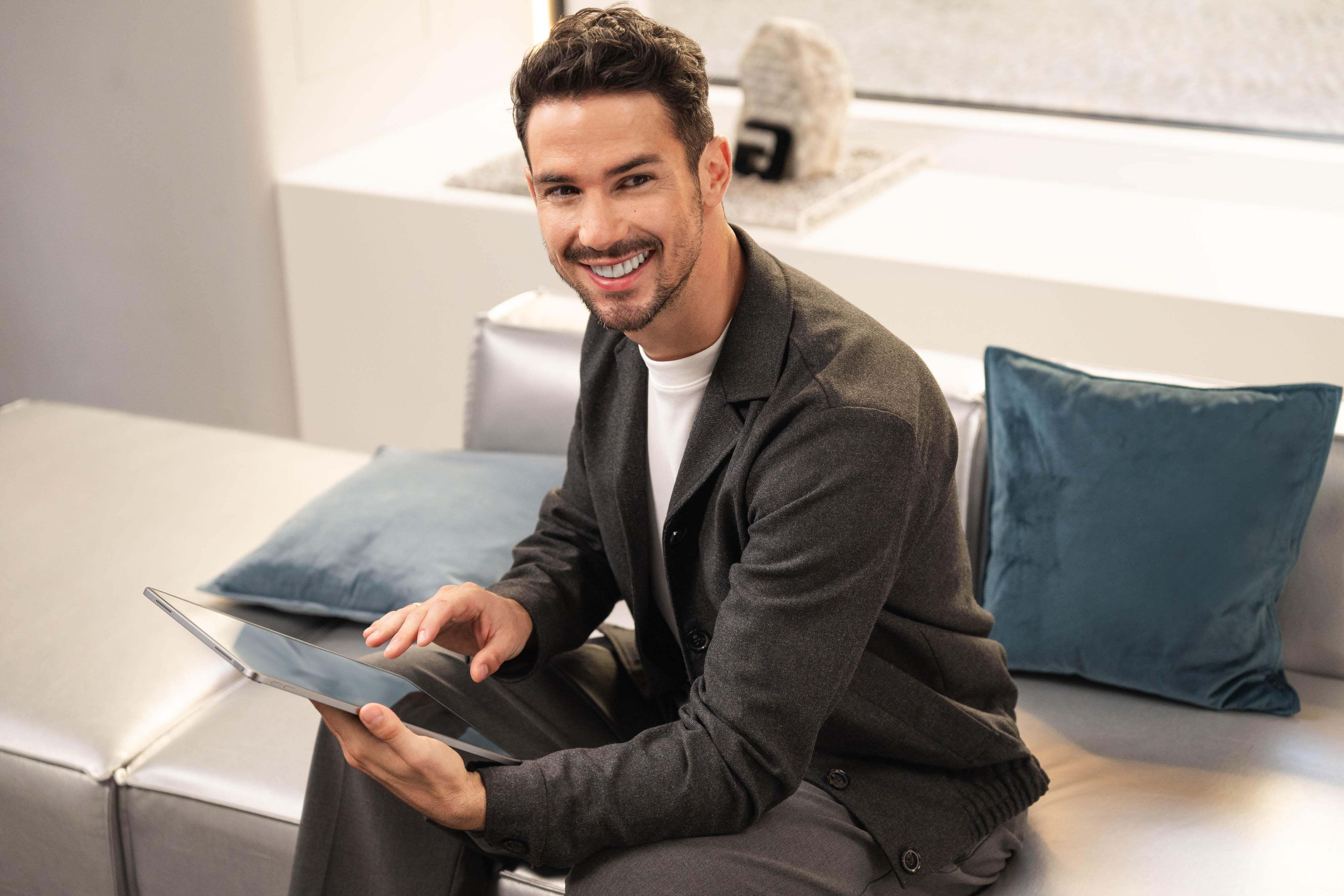 Achat d'un véhicule Un homme utilise une tablette et sourit.