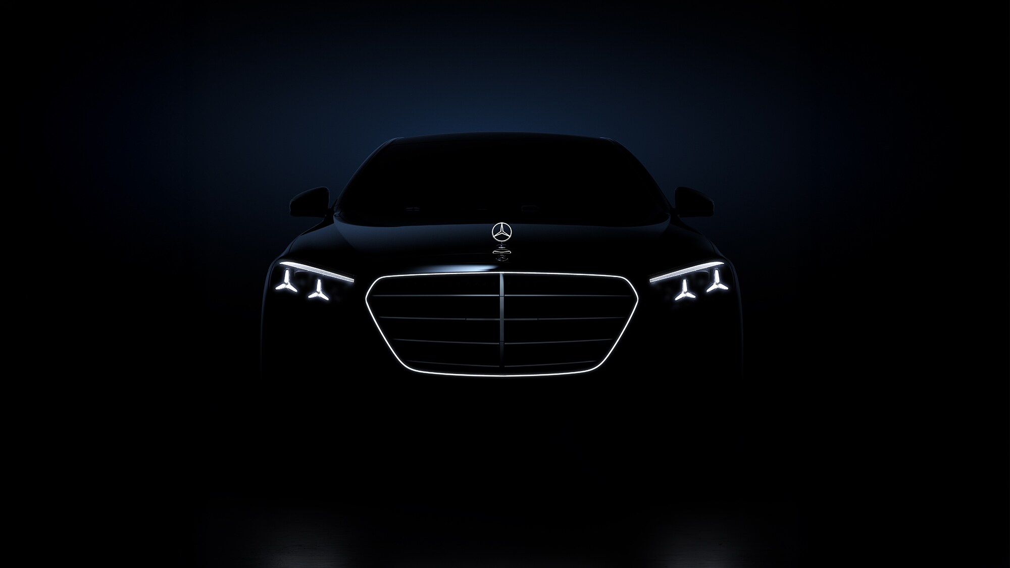 Vue avant d’une berline de luxe en éclairage sombre.