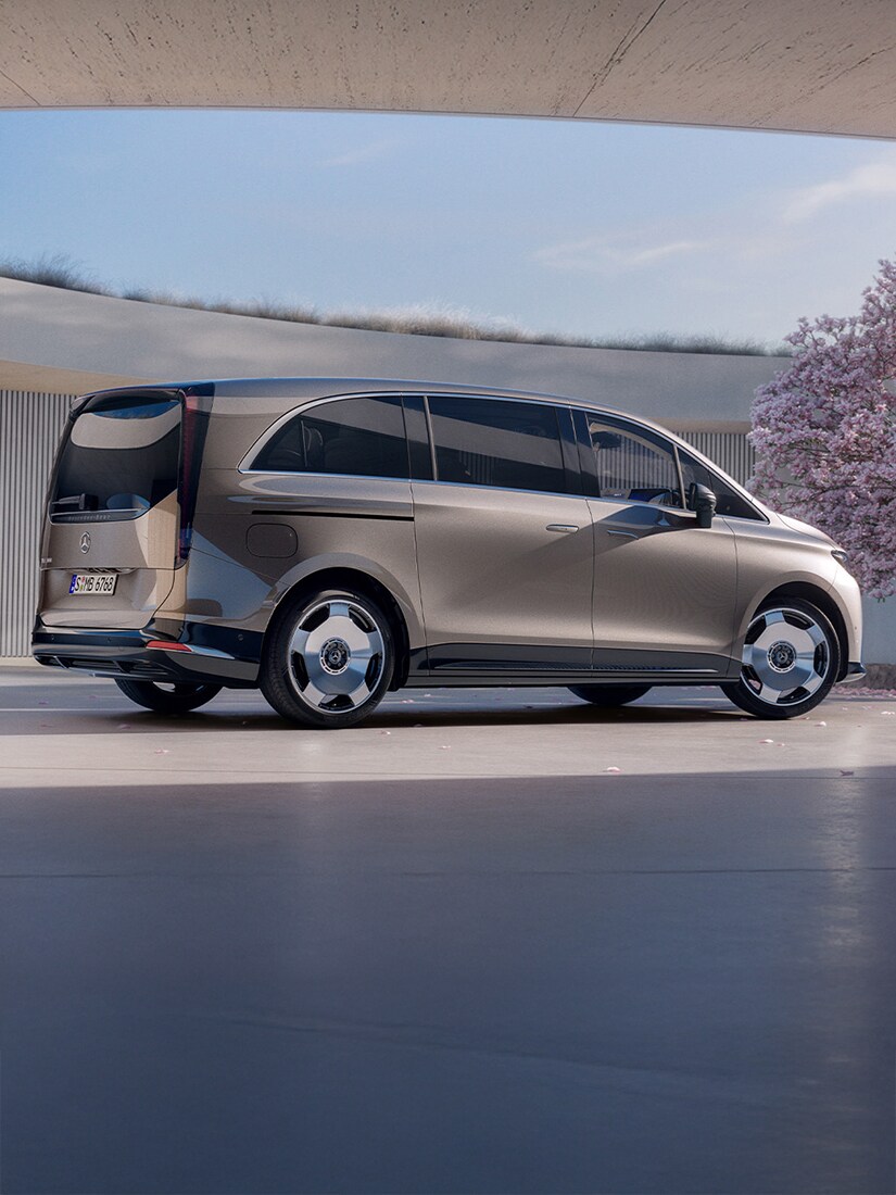 Gezeigt wird der VLE von Mercedes-Benz. Parkend vor einem modernem Gebäude mit einem Kirschbaum an der Seite.