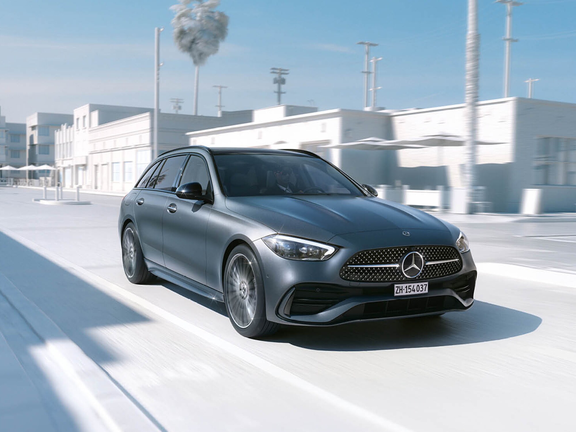 Berline Mercedes grise roulant dans un décor urbain moderne.