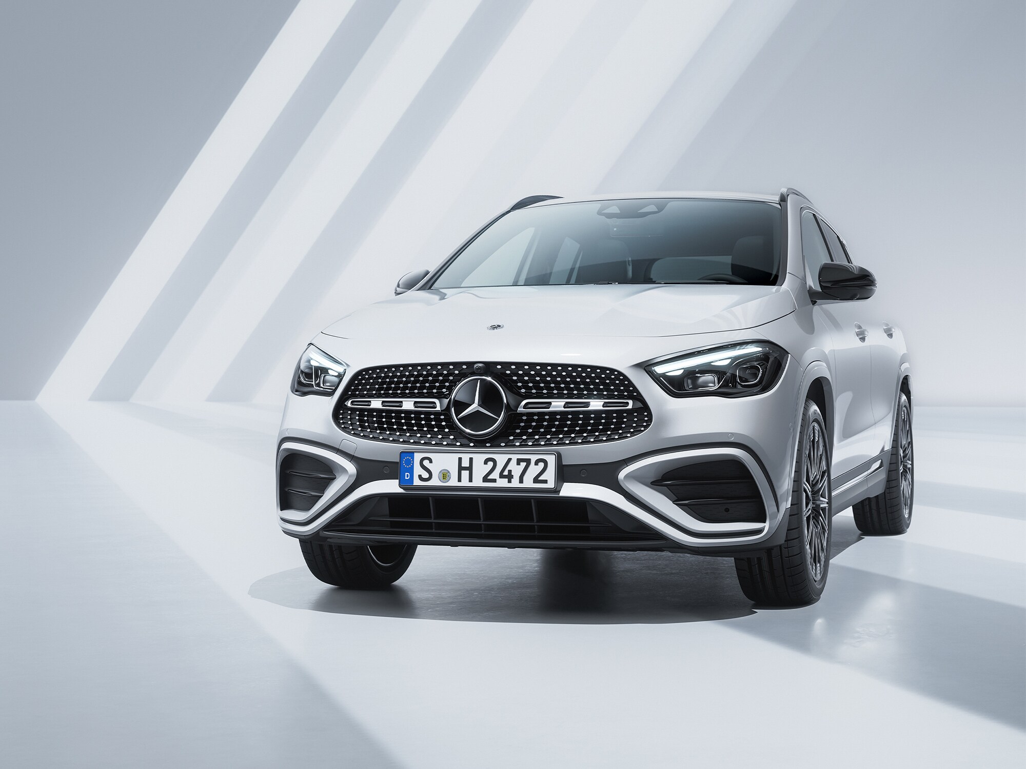 SUV Mercedes bianco in un ambiente chiaro e geometrico.