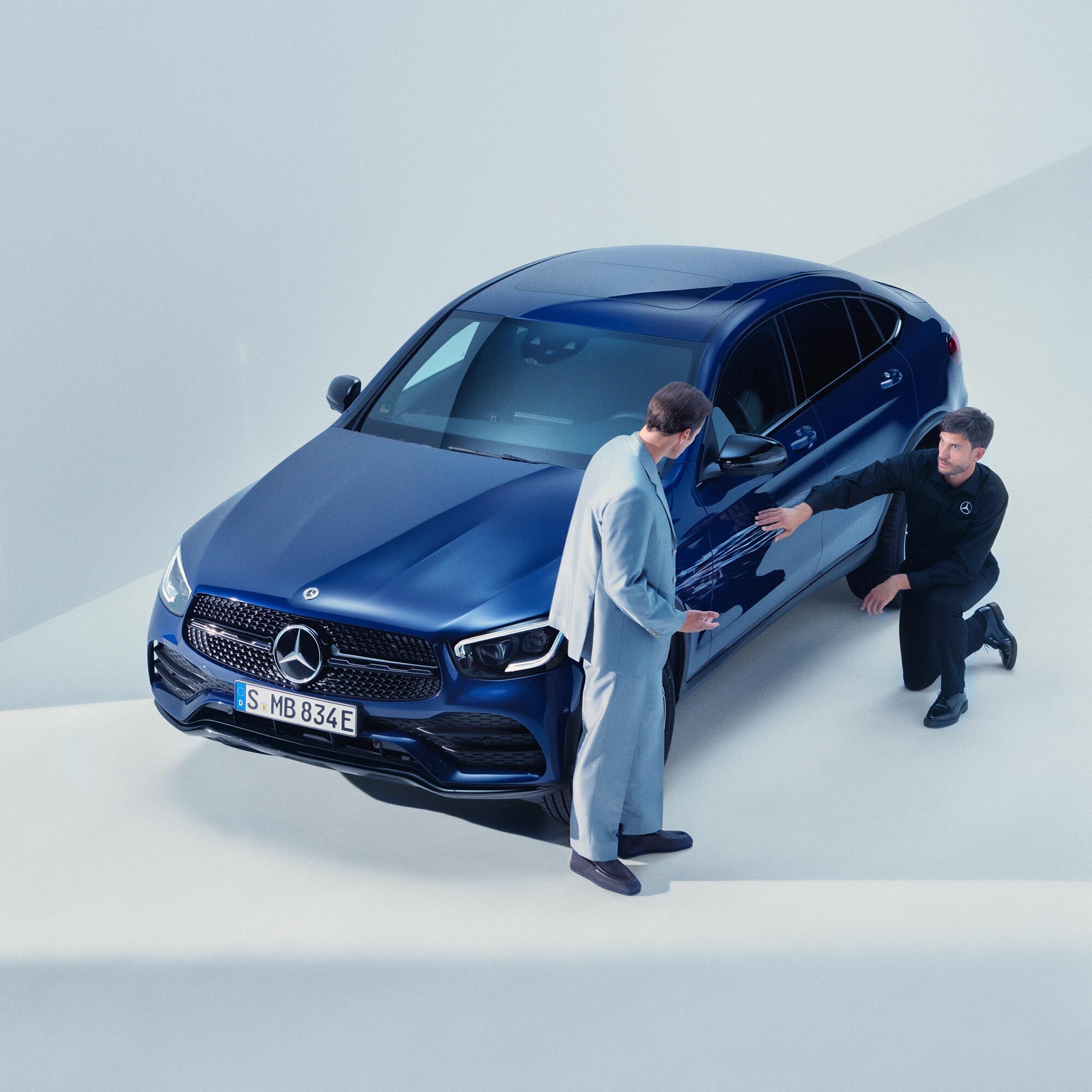 Un technicien inspectant un véhicule Mercedes-Benz et conseillant un client.