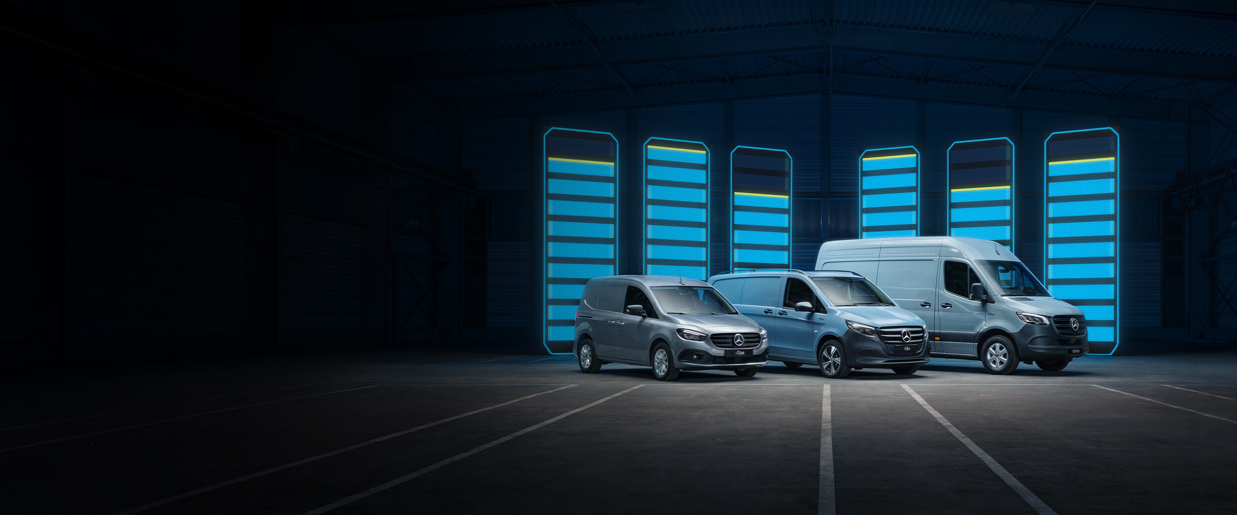 Trois utilitaires légers Mercedes-Benz dans un environnement moderne et clair en béton.