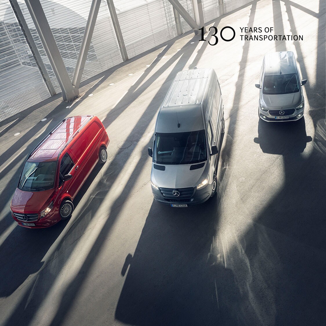 Zwei Lieferwagen vor modernem Betongebäude