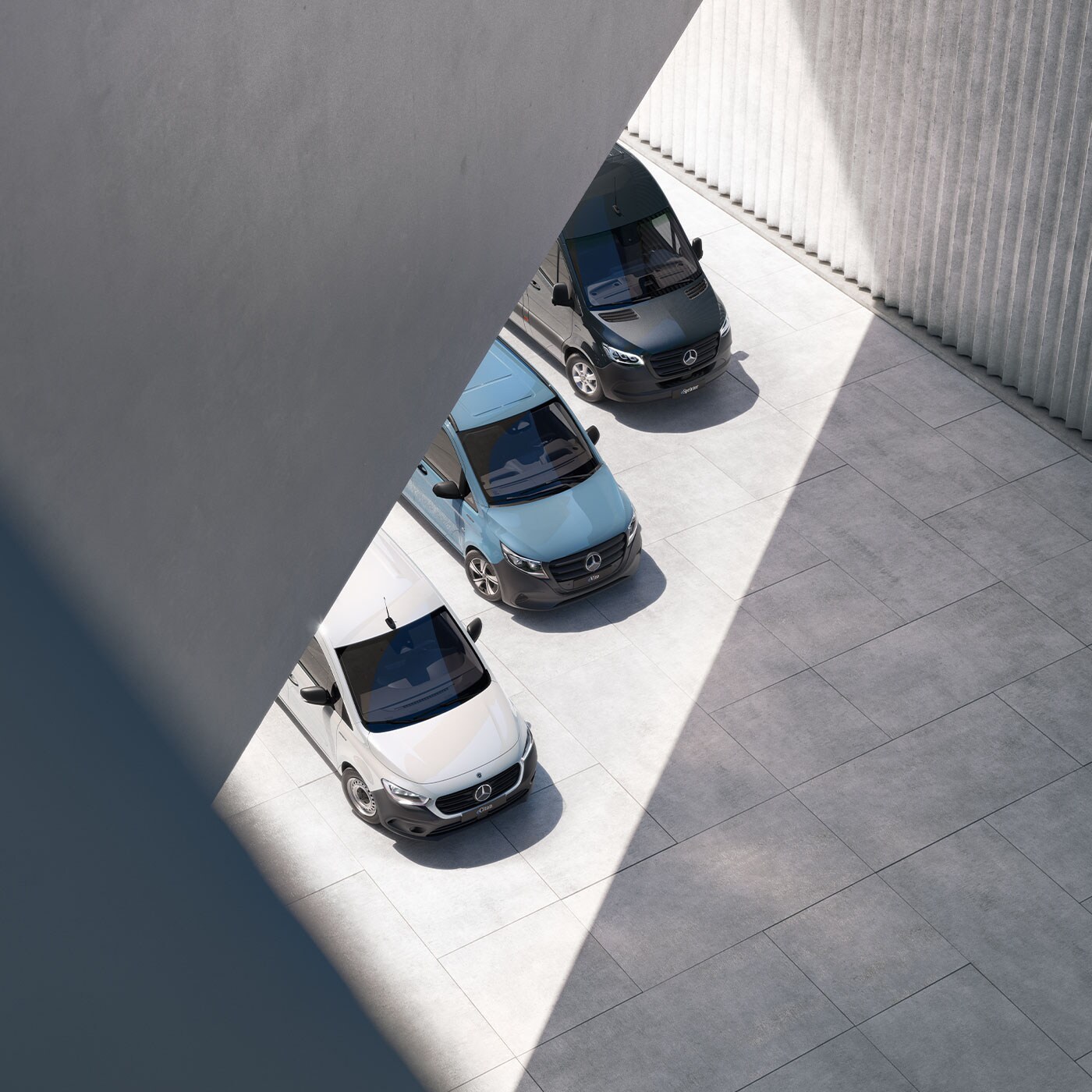 Quatre vans Mercedes-Benz garés côte à côte dans une architecture moderne avec des jeux de lumière et d’ombre.