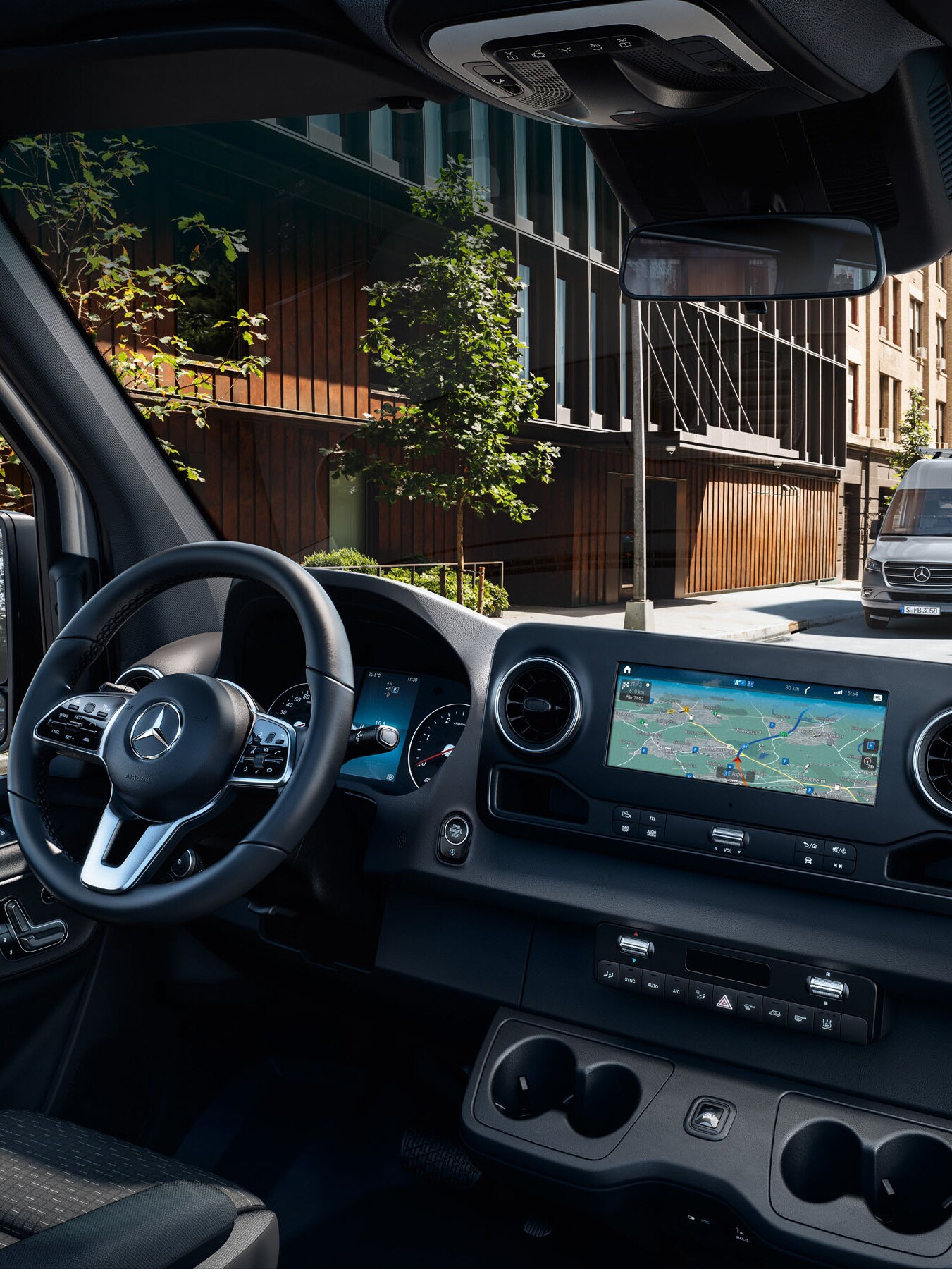 Mechaniker bei der Kontrolle eines weißen Mercedes-Benz Transporters mit einem Tablet und steht dabei für die Qualitätsstandards und das Qualitätsversprechen.