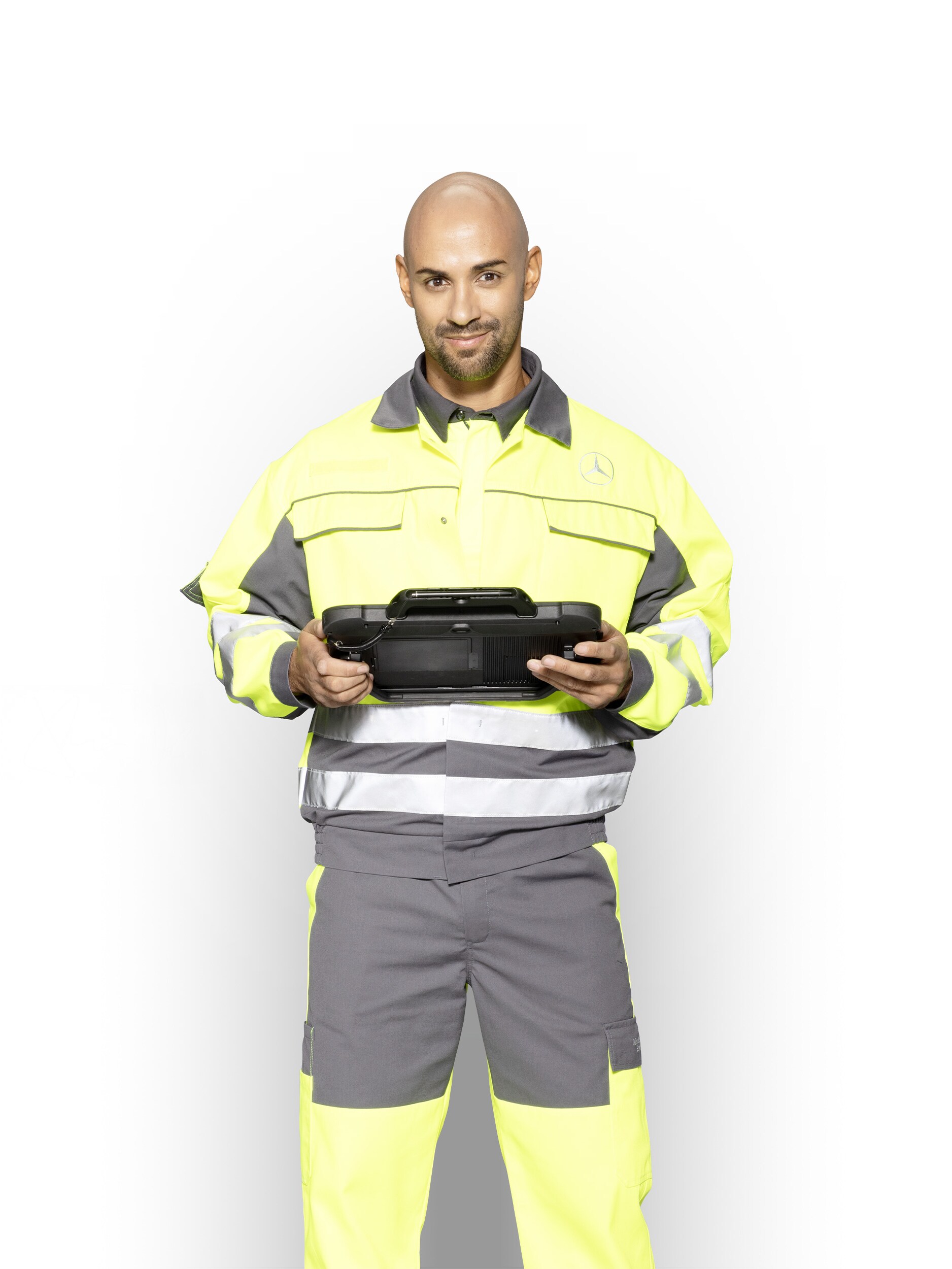 Technicien de maintenance en tenue de travail, tablette à la main, pour assurer un soutien compétent de la part de Mercedes-Benz .