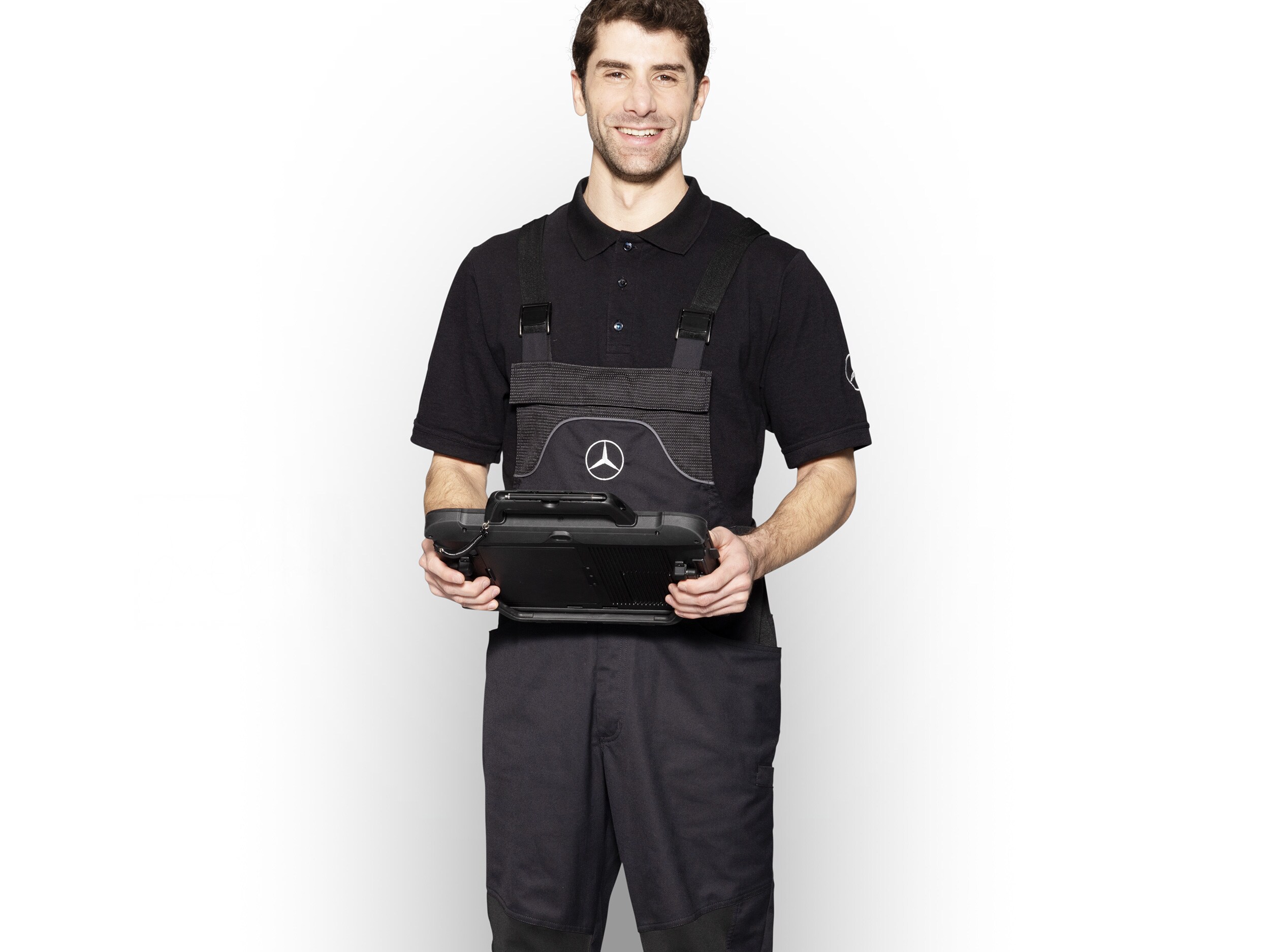 Un meccanico Mercedes-Benz con indumenti abiti da lavoro con in mano un tablet pronto per la segnalazione dei danni.